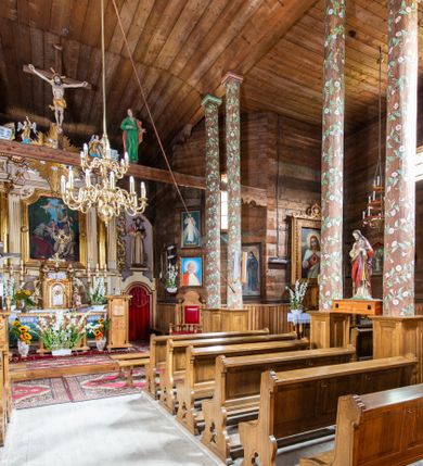 Zdjęcie nr 5: Kościół św. Joachima w Skawinkach usytuowany jest w centrum wsi, na zachód od głównej drogi prowadzącej z Palczy do Kalwarii Zebrzydowskiej. Teren przykościelny jest usytuowany na wysokim wzniesieniu, do którego prowadzą trzy wejścia, jedno przez schody, drugie przez obszerny wjazd od strony południowej.

Kościół skierowany na zachód, drewniany o konstrukcji zrębowej, na rzucie krzyża greckiego ze ściętymi kątami międzyramiennymi.  Przy prezbiterium zakrystia. Strop wsparty na czterech parach słupów, ustawionych w krzyżu kościoła, w licu ścian ramienia wschodniego i zachodniego. Belka tęczy prosta, profilowana na kroksztynach, na niej Grupa Ukrzyżowania. Świątynia połączona za pomocą kruchty z wieżą o konstrukcji słupowej, na planie kwadratu z nadwieszoną izbicą, nakryta dachem namiotowym, ściany dzwonnicy opasane mniej więcej w połowie wysokości pulpitowym daszkiem, zlewającym się po bokach z siodłowym dachem kruchty. Do kościoła prowadzi główne wejście w przedsionku od strony południowej. Wnętrze świątyni oświetlają prostokątne okna. Dach nakryty gontem, na skrzyżowaniu ramiona krzyża greckiego wystawiona wieżyczka na sygnaturkę z latarnią. Ściany na zewnątrz pokryte szalunkiem pionowym.
