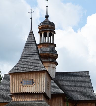 Zdjęcie nr 16: Kościół św. Joachima w Skawinkach usytuowany jest w centrum wsi, na zachód od głównej drogi prowadzącej z Palczy do Kalwarii Zebrzydowskiej. Teren przykościelny jest usytuowany na wysokim wzniesieniu, do którego prowadzą trzy wejścia, jedno przez schody, drugie przez obszerny wjazd od strony południowej.

Kościół skierowany na zachód, drewniany o konstrukcji zrębowej, na rzucie krzyża greckiego ze ściętymi kątami międzyramiennymi.  Przy prezbiterium zakrystia. Strop wsparty na czterech parach słupów, ustawionych w krzyżu kościoła, w licu ścian ramienia wschodniego i zachodniego. Belka tęczy prosta, profilowana na kroksztynach, na niej Grupa Ukrzyżowania. Świątynia połączona za pomocą kruchty z wieżą o konstrukcji słupowej, na planie kwadratu z nadwieszoną izbicą, nakryta dachem namiotowym, ściany dzwonnicy opasane mniej więcej w połowie wysokości pulpitowym daszkiem, zlewającym się po bokach z siodłowym dachem kruchty. Do kościoła prowadzi główne wejście w przedsionku od strony południowej. Wnętrze świątyni oświetlają prostokątne okna. Dach nakryty gontem, na skrzyżowaniu ramiona krzyża greckiego wystawiona wieżyczka na sygnaturkę z latarnią. Ściany na zewnątrz pokryte szalunkiem pionowym.
