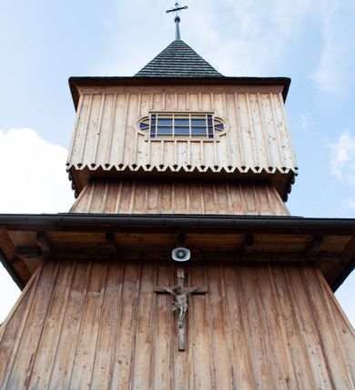 Zdjęcie nr 13: Kościół św. Joachima w Skawinkach usytuowany jest w centrum wsi, na zachód od głównej drogi prowadzącej z Palczy do Kalwarii Zebrzydowskiej. Teren przykościelny jest usytuowany na wysokim wzniesieniu, do którego prowadzą trzy wejścia, jedno przez schody, drugie przez obszerny wjazd od strony południowej.

Kościół skierowany na zachód, drewniany o konstrukcji zrębowej, na rzucie krzyża greckiego ze ściętymi kątami międzyramiennymi.  Przy prezbiterium zakrystia. Strop wsparty na czterech parach słupów, ustawionych w krzyżu kościoła, w licu ścian ramienia wschodniego i zachodniego. Belka tęczy prosta, profilowana na kroksztynach, na niej Grupa Ukrzyżowania. Świątynia połączona za pomocą kruchty z wieżą o konstrukcji słupowej, na planie kwadratu z nadwieszoną izbicą, nakryta dachem namiotowym, ściany dzwonnicy opasane mniej więcej w połowie wysokości pulpitowym daszkiem, zlewającym się po bokach z siodłowym dachem kruchty. Do kościoła prowadzi główne wejście w przedsionku od strony południowej. Wnętrze świątyni oświetlają prostokątne okna. Dach nakryty gontem, na skrzyżowaniu ramiona krzyża greckiego wystawiona wieżyczka na sygnaturkę z latarnią. Ściany na zewnątrz pokryte szalunkiem pionowym.
