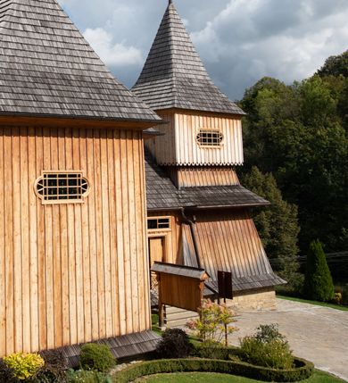 Zdjęcie nr 31: Kościół św. Joachima w Skawinkach usytuowany jest w centrum wsi, na zachód od głównej drogi prowadzącej z Palczy do Kalwarii Zebrzydowskiej. Teren przykościelny jest usytuowany na wysokim wzniesieniu, do którego prowadzą trzy wejścia, jedno przez schody, drugie przez obszerny wjazd od strony południowej.

Kościół skierowany na zachód, drewniany o konstrukcji zrębowej, na rzucie krzyża greckiego ze ściętymi kątami międzyramiennymi.  Przy prezbiterium zakrystia. Strop wsparty na czterech parach słupów, ustawionych w krzyżu kościoła, w licu ścian ramienia wschodniego i zachodniego. Belka tęczy prosta, profilowana na kroksztynach, na niej Grupa Ukrzyżowania. Świątynia połączona za pomocą kruchty z wieżą o konstrukcji słupowej, na planie kwadratu z nadwieszoną izbicą, nakryta dachem namiotowym, ściany dzwonnicy opasane mniej więcej w połowie wysokości pulpitowym daszkiem, zlewającym się po bokach z siodłowym dachem kruchty. Do kościoła prowadzi główne wejście w przedsionku od strony południowej. Wnętrze świątyni oświetlają prostokątne okna. Dach nakryty gontem, na skrzyżowaniu ramiona krzyża greckiego wystawiona wieżyczka na sygnaturkę z latarnią. Ściany na zewnątrz pokryte szalunkiem pionowym.
