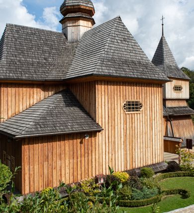 Zdjęcie nr 33: Kościół św. Joachima w Skawinkach usytuowany jest w centrum wsi, na zachód od głównej drogi prowadzącej z Palczy do Kalwarii Zebrzydowskiej. Teren przykościelny jest usytuowany na wysokim wzniesieniu, do którego prowadzą trzy wejścia, jedno przez schody, drugie przez obszerny wjazd od strony południowej.

Kościół skierowany na zachód, drewniany o konstrukcji zrębowej, na rzucie krzyża greckiego ze ściętymi kątami międzyramiennymi.  Przy prezbiterium zakrystia. Strop wsparty na czterech parach słupów, ustawionych w krzyżu kościoła, w licu ścian ramienia wschodniego i zachodniego. Belka tęczy prosta, profilowana na kroksztynach, na niej Grupa Ukrzyżowania. Świątynia połączona za pomocą kruchty z wieżą o konstrukcji słupowej, na planie kwadratu z nadwieszoną izbicą, nakryta dachem namiotowym, ściany dzwonnicy opasane mniej więcej w połowie wysokości pulpitowym daszkiem, zlewającym się po bokach z siodłowym dachem kruchty. Do kościoła prowadzi główne wejście w przedsionku od strony południowej. Wnętrze świątyni oświetlają prostokątne okna. Dach nakryty gontem, na skrzyżowaniu ramiona krzyża greckiego wystawiona wieżyczka na sygnaturkę z latarnią. Ściany na zewnątrz pokryte szalunkiem pionowym.
