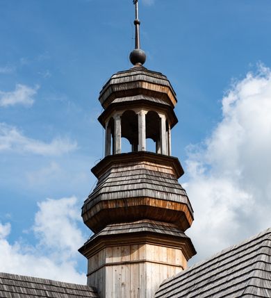 Zdjęcie nr 35: Kościół św. Joachima w Skawinkach usytuowany jest w centrum wsi, na zachód od głównej drogi prowadzącej z Palczy do Kalwarii Zebrzydowskiej. Teren przykościelny jest usytuowany na wysokim wzniesieniu, do którego prowadzą trzy wejścia, jedno przez schody, drugie przez obszerny wjazd od strony południowej.

Kościół skierowany na zachód, drewniany o konstrukcji zrębowej, na rzucie krzyża greckiego ze ściętymi kątami międzyramiennymi.  Przy prezbiterium zakrystia. Strop wsparty na czterech parach słupów, ustawionych w krzyżu kościoła, w licu ścian ramienia wschodniego i zachodniego. Belka tęczy prosta, profilowana na kroksztynach, na niej Grupa Ukrzyżowania. Świątynia połączona za pomocą kruchty z wieżą o konstrukcji słupowej, na planie kwadratu z nadwieszoną izbicą, nakryta dachem namiotowym, ściany dzwonnicy opasane mniej więcej w połowie wysokości pulpitowym daszkiem, zlewającym się po bokach z siodłowym dachem kruchty. Do kościoła prowadzi główne wejście w przedsionku od strony południowej. Wnętrze świątyni oświetlają prostokątne okna. Dach nakryty gontem, na skrzyżowaniu ramiona krzyża greckiego wystawiona wieżyczka na sygnaturkę z latarnią. Ściany na zewnątrz pokryte szalunkiem pionowym.
