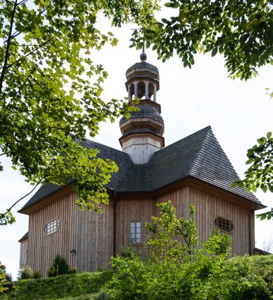 Zdjęcie nr 40: Kościół św. Joachima w Skawinkach usytuowany jest w centrum wsi, na zachód od głównej drogi prowadzącej z Palczy do Kalwarii Zebrzydowskiej. Teren przykościelny jest usytuowany na wysokim wzniesieniu, do którego prowadzą trzy wejścia, jedno przez schody, drugie przez obszerny wjazd od strony południowej.

Kościół skierowany na zachód, drewniany o konstrukcji zrębowej, na rzucie krzyża greckiego ze ściętymi kątami międzyramiennymi.  Przy prezbiterium zakrystia. Strop wsparty na czterech parach słupów, ustawionych w krzyżu kościoła, w licu ścian ramienia wschodniego i zachodniego. Belka tęczy prosta, profilowana na kroksztynach, na niej Grupa Ukrzyżowania. Świątynia połączona za pomocą kruchty z wieżą o konstrukcji słupowej, na planie kwadratu z nadwieszoną izbicą, nakryta dachem namiotowym, ściany dzwonnicy opasane mniej więcej w połowie wysokości pulpitowym daszkiem, zlewającym się po bokach z siodłowym dachem kruchty. Do kościoła prowadzi główne wejście w przedsionku od strony południowej. Wnętrze świątyni oświetlają prostokątne okna. Dach nakryty gontem, na skrzyżowaniu ramiona krzyża greckiego wystawiona wieżyczka na sygnaturkę z latarnią. Ściany na zewnątrz pokryte szalunkiem pionowym.
