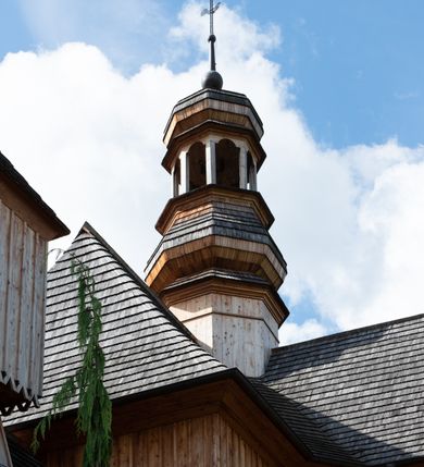 Zdjęcie nr 43: Kościół św. Joachima w Skawinkach usytuowany jest w centrum wsi, na zachód od głównej drogi prowadzącej z Palczy do Kalwarii Zebrzydowskiej. Teren przykościelny jest usytuowany na wysokim wzniesieniu, do którego prowadzą trzy wejścia, jedno przez schody, drugie przez obszerny wjazd od strony południowej.

Kościół skierowany na zachód, drewniany o konstrukcji zrębowej, na rzucie krzyża greckiego ze ściętymi kątami międzyramiennymi.  Przy prezbiterium zakrystia. Strop wsparty na czterech parach słupów, ustawionych w krzyżu kościoła, w licu ścian ramienia wschodniego i zachodniego. Belka tęczy prosta, profilowana na kroksztynach, na niej Grupa Ukrzyżowania. Świątynia połączona za pomocą kruchty z wieżą o konstrukcji słupowej, na planie kwadratu z nadwieszoną izbicą, nakryta dachem namiotowym, ściany dzwonnicy opasane mniej więcej w połowie wysokości pulpitowym daszkiem, zlewającym się po bokach z siodłowym dachem kruchty. Do kościoła prowadzi główne wejście w przedsionku od strony południowej. Wnętrze świątyni oświetlają prostokątne okna. Dach nakryty gontem, na skrzyżowaniu ramiona krzyża greckiego wystawiona wieżyczka na sygnaturkę z latarnią. Ściany na zewnątrz pokryte szalunkiem pionowym.
