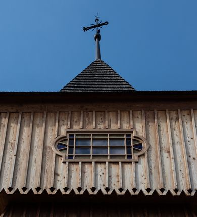 Zdjęcie nr 47: Kościół św. Joachima w Skawinkach usytuowany jest w centrum wsi, na zachód od głównej drogi prowadzącej z Palczy do Kalwarii Zebrzydowskiej. Teren przykościelny jest usytuowany na wysokim wzniesieniu, do którego prowadzą trzy wejścia, jedno przez schody, drugie przez obszerny wjazd od strony południowej.

Kościół skierowany na zachód, drewniany o konstrukcji zrębowej, na rzucie krzyża greckiego ze ściętymi kątami międzyramiennymi.  Przy prezbiterium zakrystia. Strop wsparty na czterech parach słupów, ustawionych w krzyżu kościoła, w licu ścian ramienia wschodniego i zachodniego. Belka tęczy prosta, profilowana na kroksztynach, na niej Grupa Ukrzyżowania. Świątynia połączona za pomocą kruchty z wieżą o konstrukcji słupowej, na planie kwadratu z nadwieszoną izbicą, nakryta dachem namiotowym, ściany dzwonnicy opasane mniej więcej w połowie wysokości pulpitowym daszkiem, zlewającym się po bokach z siodłowym dachem kruchty. Do kościoła prowadzi główne wejście w przedsionku od strony południowej. Wnętrze świątyni oświetlają prostokątne okna. Dach nakryty gontem, na skrzyżowaniu ramiona krzyża greckiego wystawiona wieżyczka na sygnaturkę z latarnią. Ściany na zewnątrz pokryte szalunkiem pionowym.
