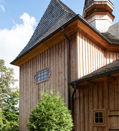 Zdjęcie nr 56: Kościół św. Joachima w Skawinkach usytuowany jest w centrum wsi, na zachód od głównej drogi prowadzącej z Palczy do Kalwarii Zebrzydowskiej. Teren przykościelny jest usytuowany na wysokim wzniesieniu, do którego prowadzą trzy wejścia, jedno przez schody, drugie przez obszerny wjazd od strony południowej.

Kościół skierowany na zachód, drewniany o konstrukcji zrębowej, na rzucie krzyża greckiego ze ściętymi kątami międzyramiennymi.  Przy prezbiterium zakrystia. Strop wsparty na czterech parach słupów, ustawionych w krzyżu kościoła, w licu ścian ramienia wschodniego i zachodniego. Belka tęczy prosta, profilowana na kroksztynach, na niej Grupa Ukrzyżowania. Świątynia połączona za pomocą kruchty z wieżą o konstrukcji słupowej, na planie kwadratu z nadwieszoną izbicą, nakryta dachem namiotowym, ściany dzwonnicy opasane mniej więcej w połowie wysokości pulpitowym daszkiem, zlewającym się po bokach z siodłowym dachem kruchty. Do kościoła prowadzi główne wejście w przedsionku od strony południowej. Wnętrze świątyni oświetlają prostokątne okna. Dach nakryty gontem, na skrzyżowaniu ramiona krzyża greckiego wystawiona wieżyczka na sygnaturkę z latarnią. Ściany na zewnątrz pokryte szalunkiem pionowym.
