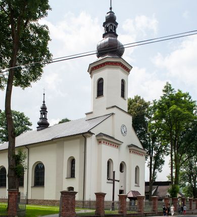 Zdjęcie nr 2: Kościół murowany, orientowany, z półkoliście zamkniętym prezbiterium, zakrystią od północy i kaplicą od południa, z przedsionkiem i wieżą od zachodu. Budynek trójnawowy, trójprzęsłowy, z nawą główną szerszą od bocznych, oddzieloną filarami, ze sklepieniem kolebkowym z gurtami. Od zachodu chór muzyczny wsparty na filarach. Ściany artykułowane pilastrami, do których dochodzą gurty sklepienia, prezbiterium oddzielone łukiem tęczowym z napisem „OTO BARANEK BOŻY”. Między pilastrami naw bocznych oraz po obu stronach ołtarza okna w kształcie stojącego prostokąta zamkniętego półkoliście. Mniejsze w kaplicy, zakrystii, przedsionku, oraz z czterech stron wieży. Główne drzwi od wschodu, boczne od północy, kolejne do zakrystii. 
Fasada trójosiowa, dwukondygnacyjna, zakończona wieżą z hełmem. Osie wydzielone są występami, kondygnacja artykułowana fragmentami gzymsu. W dolnej kondygnacji drzwi o wykroju prostokątnym, powyżej okulus. W osiach bocznych wąskie okna w kształcie stojącego prostokąta zamkniętego półkoliście, powyżej pod fragmentami gzymsu rzędy ornamentu kostkowego. W drugiej kondygnacji, na występującym fragmencie ściany tarcza zegara. Powyżej kondygnacja ośmiobocznej wieży, z czterech stron przeprutej wąskimi oknami o wykroju jak w fasadzie. Ściany boczne kościoła gładkie, przedsionek zaznaczony płaskimi lizenami, okna umieszczone we wnękach. Nawa główna, kaplica oraz kruchta nakryte dachami dwuspadowymi, prezbiterium dwuspadowym zamkniętym półkoliście. Wieża zwieńczona hełmem o rozbudowanej konstrukcji. Na zwężającym się dachu cebulasta kopuła zakończona latarnią przeprutą arkadkami zwieńczoną mniejszą kopułką cebulastą zakończoną krzyżem na kuli. 

Do najstarszych elementów wyposażenia należą kamienna siedemnastowieczna chrzcielnica, krucyfiks z tego samego okresu oraz osiemnastowieczna rzeźba Chrystusa Frasobliwego.