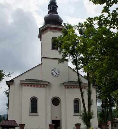 Zdjęcie nr 3: Kościół murowany, orientowany, z półkoliście zamkniętym prezbiterium, zakrystią od północy i kaplicą od południa, z przedsionkiem i wieżą od zachodu. Budynek trójnawowy, trójprzęsłowy, z nawą główną szerszą od bocznych, oddzieloną filarami, ze sklepieniem kolebkowym z gurtami. Od zachodu chór muzyczny wsparty na filarach. Ściany artykułowane pilastrami, do których dochodzą gurty sklepienia, prezbiterium oddzielone łukiem tęczowym z napisem „OTO BARANEK BOŻY”. Między pilastrami naw bocznych oraz po obu stronach ołtarza okna w kształcie stojącego prostokąta zamkniętego półkoliście. Mniejsze w kaplicy, zakrystii, przedsionku, oraz z czterech stron wieży. Główne drzwi od wschodu, boczne od północy, kolejne do zakrystii. 
Fasada trójosiowa, dwukondygnacyjna, zakończona wieżą z hełmem. Osie wydzielone są występami, kondygnacja artykułowana fragmentami gzymsu. W dolnej kondygnacji drzwi o wykroju prostokątnym, powyżej okulus. W osiach bocznych wąskie okna w kształcie stojącego prostokąta zamkniętego półkoliście, powyżej pod fragmentami gzymsu rzędy ornamentu kostkowego. W drugiej kondygnacji, na występującym fragmencie ściany tarcza zegara. Powyżej kondygnacja ośmiobocznej wieży, z czterech stron przeprutej wąskimi oknami o wykroju jak w fasadzie. Ściany boczne kościoła gładkie, przedsionek zaznaczony płaskimi lizenami, okna umieszczone we wnękach. Nawa główna, kaplica oraz kruchta nakryte dachami dwuspadowymi, prezbiterium dwuspadowym zamkniętym półkoliście. Wieża zwieńczona hełmem o rozbudowanej konstrukcji. Na zwężającym się dachu cebulasta kopuła zakończona latarnią przeprutą arkadkami zwieńczoną mniejszą kopułką cebulastą zakończoną krzyżem na kuli. 

Do najstarszych elementów wyposażenia należą kamienna siedemnastowieczna chrzcielnica, krucyfiks z tego samego okresu oraz osiemnastowieczna rzeźba Chrystusa Frasobliwego.