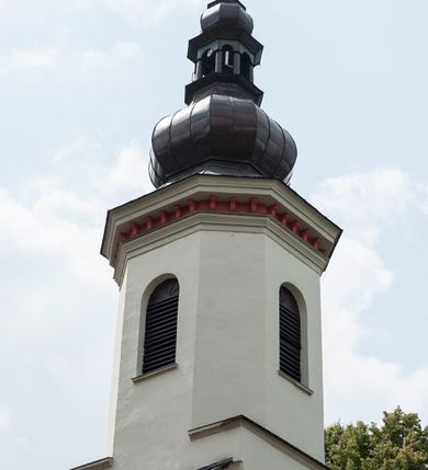 Zdjęcie nr 6: Kościół murowany, orientowany, z półkoliście zamkniętym prezbiterium, zakrystią od północy i kaplicą od południa, z przedsionkiem i wieżą od zachodu. Budynek trójnawowy, trójprzęsłowy, z nawą główną szerszą od bocznych, oddzieloną filarami, ze sklepieniem kolebkowym z gurtami. Od zachodu chór muzyczny wsparty na filarach. Ściany artykułowane pilastrami, do których dochodzą gurty sklepienia, prezbiterium oddzielone łukiem tęczowym z napisem „OTO BARANEK BOŻY”. Między pilastrami naw bocznych oraz po obu stronach ołtarza okna w kształcie stojącego prostokąta zamkniętego półkoliście. Mniejsze w kaplicy, zakrystii, przedsionku, oraz z czterech stron wieży. Główne drzwi od wschodu, boczne od północy, kolejne do zakrystii. 
Fasada trójosiowa, dwukondygnacyjna, zakończona wieżą z hełmem. Osie wydzielone są występami, kondygnacja artykułowana fragmentami gzymsu. W dolnej kondygnacji drzwi o wykroju prostokątnym, powyżej okulus. W osiach bocznych wąskie okna w kształcie stojącego prostokąta zamkniętego półkoliście, powyżej pod fragmentami gzymsu rzędy ornamentu kostkowego. W drugiej kondygnacji, na występującym fragmencie ściany tarcza zegara. Powyżej kondygnacja ośmiobocznej wieży, z czterech stron przeprutej wąskimi oknami o wykroju jak w fasadzie. Ściany boczne kościoła gładkie, przedsionek zaznaczony płaskimi lizenami, okna umieszczone we wnękach. Nawa główna, kaplica oraz kruchta nakryte dachami dwuspadowymi, prezbiterium dwuspadowym zamkniętym półkoliście. Wieża zwieńczona hełmem o rozbudowanej konstrukcji. Na zwężającym się dachu cebulasta kopuła zakończona latarnią przeprutą arkadkami zwieńczoną mniejszą kopułką cebulastą zakończoną krzyżem na kuli. 

Do najstarszych elementów wyposażenia należą kamienna siedemnastowieczna chrzcielnica, krucyfiks z tego samego okresu oraz osiemnastowieczna rzeźba Chrystusa Frasobliwego.