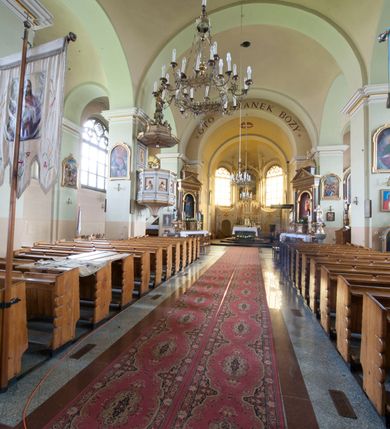 Zdjęcie nr 14: Kościół murowany, orientowany, z półkoliście zamkniętym prezbiterium, zakrystią od północy i kaplicą od południa, z przedsionkiem i wieżą od zachodu. Budynek trójnawowy, trójprzęsłowy, z nawą główną szerszą od bocznych, oddzieloną filarami, ze sklepieniem kolebkowym z gurtami. Od zachodu chór muzyczny wsparty na filarach. Ściany artykułowane pilastrami, do których dochodzą gurty sklepienia, prezbiterium oddzielone łukiem tęczowym z napisem „OTO BARANEK BOŻY”. Między pilastrami naw bocznych oraz po obu stronach ołtarza okna w kształcie stojącego prostokąta zamkniętego półkoliście. Mniejsze w kaplicy, zakrystii, przedsionku, oraz z czterech stron wieży. Główne drzwi od wschodu, boczne od północy, kolejne do zakrystii. 
Fasada trójosiowa, dwukondygnacyjna, zakończona wieżą z hełmem. Osie wydzielone są występami, kondygnacja artykułowana fragmentami gzymsu. W dolnej kondygnacji drzwi o wykroju prostokątnym, powyżej okulus. W osiach bocznych wąskie okna w kształcie stojącego prostokąta zamkniętego półkoliście, powyżej pod fragmentami gzymsu rzędy ornamentu kostkowego. W drugiej kondygnacji, na występującym fragmencie ściany tarcza zegara. Powyżej kondygnacja ośmiobocznej wieży, z czterech stron przeprutej wąskimi oknami o wykroju jak w fasadzie. Ściany boczne kościoła gładkie, przedsionek zaznaczony płaskimi lizenami, okna umieszczone we wnękach. Nawa główna, kaplica oraz kruchta nakryte dachami dwuspadowymi, prezbiterium dwuspadowym zamkniętym półkoliście. Wieża zwieńczona hełmem o rozbudowanej konstrukcji. Na zwężającym się dachu cebulasta kopuła zakończona latarnią przeprutą arkadkami zwieńczoną mniejszą kopułką cebulastą zakończoną krzyżem na kuli. 

Do najstarszych elementów wyposażenia należą kamienna siedemnastowieczna chrzcielnica, krucyfiks z tego samego okresu oraz osiemnastowieczna rzeźba Chrystusa Frasobliwego.