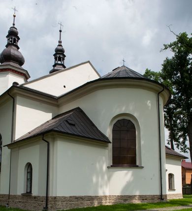 Zdjęcie nr 7: Kościół murowany, orientowany, z półkoliście zamkniętym prezbiterium, zakrystią od północy i kaplicą od południa, z przedsionkiem i wieżą od zachodu. Budynek trójnawowy, trójprzęsłowy, z nawą główną szerszą od bocznych, oddzieloną filarami, ze sklepieniem kolebkowym z gurtami. Od zachodu chór muzyczny wsparty na filarach. Ściany artykułowane pilastrami, do których dochodzą gurty sklepienia, prezbiterium oddzielone łukiem tęczowym z napisem „OTO BARANEK BOŻY”. Między pilastrami naw bocznych oraz po obu stronach ołtarza okna w kształcie stojącego prostokąta zamkniętego półkoliście. Mniejsze w kaplicy, zakrystii, przedsionku, oraz z czterech stron wieży. Główne drzwi od wschodu, boczne od północy, kolejne do zakrystii. 
Fasada trójosiowa, dwukondygnacyjna, zakończona wieżą z hełmem. Osie wydzielone są występami, kondygnacja artykułowana fragmentami gzymsu. W dolnej kondygnacji drzwi o wykroju prostokątnym, powyżej okulus. W osiach bocznych wąskie okna w kształcie stojącego prostokąta zamkniętego półkoliście, powyżej pod fragmentami gzymsu rzędy ornamentu kostkowego. W drugiej kondygnacji, na występującym fragmencie ściany tarcza zegara. Powyżej kondygnacja ośmiobocznej wieży, z czterech stron przeprutej wąskimi oknami o wykroju jak w fasadzie. Ściany boczne kościoła gładkie, przedsionek zaznaczony płaskimi lizenami, okna umieszczone we wnękach. Nawa główna, kaplica oraz kruchta nakryte dachami dwuspadowymi, prezbiterium dwuspadowym zamkniętym półkoliście. Wieża zwieńczona hełmem o rozbudowanej konstrukcji. Na zwężającym się dachu cebulasta kopuła zakończona latarnią przeprutą arkadkami zwieńczoną mniejszą kopułką cebulastą zakończoną krzyżem na kuli. 

Do najstarszych elementów wyposażenia należą kamienna siedemnastowieczna chrzcielnica, krucyfiks z tego samego okresu oraz osiemnastowieczna rzeźba Chrystusa Frasobliwego.