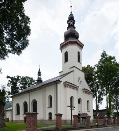 Zdjęcie nr 1: Kościół murowany, orientowany, z półkoliście zamkniętym prezbiterium, zakrystią od północy i kaplicą od południa, z przedsionkiem i wieżą od zachodu. Budynek trójnawowy, trójprzęsłowy, z nawą główną szerszą od bocznych, oddzieloną filarami, ze sklepieniem kolebkowym z gurtami. Od zachodu chór muzyczny wsparty na filarach. Ściany artykułowane pilastrami, do których dochodzą gurty sklepienia, prezbiterium oddzielone łukiem tęczowym z napisem „OTO BARANEK BOŻY”. Między pilastrami naw bocznych oraz po obu stronach ołtarza okna w kształcie stojącego prostokąta zamkniętego półkoliście. Mniejsze w kaplicy, zakrystii, przedsionku, oraz z czterech stron wieży. Główne drzwi od wschodu, boczne od północy, kolejne do zakrystii. 
Fasada trójosiowa, dwukondygnacyjna, zakończona wieżą z hełmem. Osie wydzielone są występami, kondygnacja artykułowana fragmentami gzymsu. W dolnej kondygnacji drzwi o wykroju prostokątnym, powyżej okulus. W osiach bocznych wąskie okna w kształcie stojącego prostokąta zamkniętego półkoliście, powyżej pod fragmentami gzymsu rzędy ornamentu kostkowego. W drugiej kondygnacji, na występującym fragmencie ściany tarcza zegara. Powyżej kondygnacja ośmiobocznej wieży, z czterech stron przeprutej wąskimi oknami o wykroju jak w fasadzie. Ściany boczne kościoła gładkie, przedsionek zaznaczony płaskimi lizenami, okna umieszczone we wnękach. Nawa główna, kaplica oraz kruchta nakryte dachami dwuspadowymi, prezbiterium dwuspadowym zamkniętym półkoliście. Wieża zwieńczona hełmem o rozbudowanej konstrukcji. Na zwężającym się dachu cebulasta kopuła zakończona latarnią przeprutą arkadkami zwieńczoną mniejszą kopułką cebulastą zakończoną krzyżem na kuli. 

Do najstarszych elementów wyposażenia należą kamienna siedemnastowieczna chrzcielnica, krucyfiks z tego samego okresu oraz osiemnastowieczna rzeźba Chrystusa Frasobliwego.