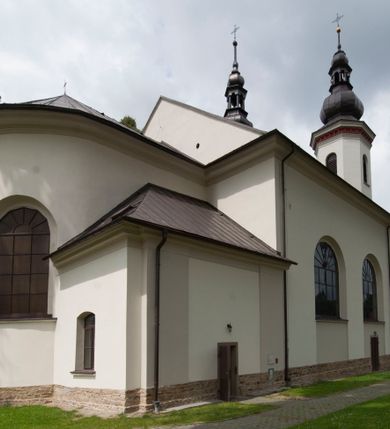Zdjęcie nr 10: Kościół murowany, orientowany, z półkoliście zamkniętym prezbiterium, zakrystią od północy i kaplicą od południa, z przedsionkiem i wieżą od zachodu. Budynek trójnawowy, trójprzęsłowy, z nawą główną szerszą od bocznych, oddzieloną filarami, ze sklepieniem kolebkowym z gurtami. Od zachodu chór muzyczny wsparty na filarach. Ściany artykułowane pilastrami, do których dochodzą gurty sklepienia, prezbiterium oddzielone łukiem tęczowym z napisem „OTO BARANEK BOŻY”. Między pilastrami naw bocznych oraz po obu stronach ołtarza okna w kształcie stojącego prostokąta zamkniętego półkoliście. Mniejsze w kaplicy, zakrystii, przedsionku, oraz z czterech stron wieży. Główne drzwi od wschodu, boczne od północy, kolejne do zakrystii. 
Fasada trójosiowa, dwukondygnacyjna, zakończona wieżą z hełmem. Osie wydzielone są występami, kondygnacja artykułowana fragmentami gzymsu. W dolnej kondygnacji drzwi o wykroju prostokątnym, powyżej okulus. W osiach bocznych wąskie okna w kształcie stojącego prostokąta zamkniętego półkoliście, powyżej pod fragmentami gzymsu rzędy ornamentu kostkowego. W drugiej kondygnacji, na występującym fragmencie ściany tarcza zegara. Powyżej kondygnacja ośmiobocznej wieży, z czterech stron przeprutej wąskimi oknami o wykroju jak w fasadzie. Ściany boczne kościoła gładkie, przedsionek zaznaczony płaskimi lizenami, okna umieszczone we wnękach. Nawa główna, kaplica oraz kruchta nakryte dachami dwuspadowymi, prezbiterium dwuspadowym zamkniętym półkoliście. Wieża zwieńczona hełmem o rozbudowanej konstrukcji. Na zwężającym się dachu cebulasta kopuła zakończona latarnią przeprutą arkadkami zwieńczoną mniejszą kopułką cebulastą zakończoną krzyżem na kuli. 

Do najstarszych elementów wyposażenia należą kamienna siedemnastowieczna chrzcielnica, krucyfiks z tego samego okresu oraz osiemnastowieczna rzeźba Chrystusa Frasobliwego.