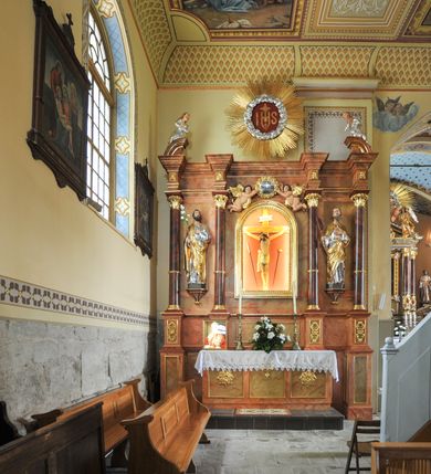Zdjęcie nr 3: Kościół murowany, orientowany, z półkoliście zamkniętym prezbiterium, niewielką zakrystią od północy, z przedsionkiem i wieżą od zachodu. Budynek trójnawowy, trójprzęsłowy, z nawą główną szerszą od bocznych, oddzieloną filarami, ze sklepieniem zwierciadlanym. Prezbiterium oddzielone łukiem tęczowym, dwuprzęsłowe, nakryte sklepieniem żaglastym z gurtami. Od zachodu chór muzyczny wsparty na ściankach i filarach przechodzących w pilastry. Ściany artykułowane płaskimi pilastrami. Ściany, podpory oraz sklepienie pokryte polichromią.
Między pilastrami naw bocznych oraz po obu stronach ołtarza okna w kształcie stojącego prostokąta zamkniętego półkoliście. Dwa mniejsze okna w przedsionku, po jednym w drugiej i trzeciej kondygnacji wieży od zachodu, w czwartej kondygnacji z czterech stron. Główne drzwi od wschodu, boczne od północy, kolejne do północy do zakrystii. 
Fasada kościoła trójosiowa, czterokondygnacyjna, z wieżą na osi. Osie wydzielone są lizenami na narożach występu wieży, kondygnacje artykułowane otworami. Do wejścia prowadzą  drzwi w kształcie stojącego prostokąta w niszy zamkniętej łukiem koszowym, w drugiej kondygnacji balkon, w którym na tle okna figura Marii. W osiach bocznych wąskie okna w kształcie stojącego prostokąta zamkniętego półkoliście. Kondygnacje oddzielone niezbyt wydatnym gzymsem. Dwie górne kondygnacje przeprute oknami, w ostatniej kondygnacji wieża przechodzi w ośmioboczną. Tynkowane ściany boczne naw oraz prezbiterium artykułowane murowanymi z kamienia lizenami, pomiędzy którymi są okna umieszczone we wnękach. Nawa główna oraz kruchta nakryte dachami dwuspadowymi, prezbiterium dwuspadowym zamkniętym półkoliście. Wieża zwieńczona hełmem w formie ostrosłupa z trójkątnymi wycięciami powyżej okien ostatniej kondygnacji. Pod kościołem znajduje się wymurowania z kamienia grota, do której spływa woda ze słynącego cudami źródła. W grocie ustawiono figurę Matki Boskiej. 
Całe wyposażenie pochodzi z drugiej połowy XIX wieku. 