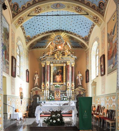 Zdjęcie nr 2: Nastawa ołtarzowa architektoniczna, jednoosiowa, jednokondygnacyjna, z bramkami, na cokole. Mensa skrzyniowa z dekorowanym antepedium. Nastawa na wysokim, pięciodzielnym cokole, którego druga i czwarta część są wysunięte do przodu. Pole główne ujęte parą pilastrów za dwiema parami kolumn dekorowanych do jednej trzeciej wysokości motywami złożonymi z ornamentów roślinnych z kaboszonami pośrodku, o kapitelach kompozytowych, dźwigających imposty i gzyms wyłamany do przodu. Środkowa para wysunięta przed lico ołtarza, zwieńczona trójkątnym przyczółkiem z kartuszem herbowym utworzonym z małżowiny z monogramem maryjnym pośrodku. Pole główne z obrazem Marii z rodzicami wymiennie z wizerunkiem Matki Boskiej Częstochowskiej i Matki Boskiej Fatimskiej w szerokiej, ażurowej, złoconej ramie. 
Zwieńczenie przyjmuje kształt glorii promienistej, w której centrum znajduje się gołębica w otoczeniu obłoków adorowana przez dwa anioły wspierające się na belkowaniu; na zewnętrznych fragmentach belkowania wazony płomieniste.  
Na bramkach przeprutych łukiem podkowiastym i zwieńczonych trójkątnym przyczółkiem posadowione na cokołach figury św. Kazimierza po lewej i św. Jana z Kęt po prawej. 
Nastawa marmoryzowana na kolor szary, płyciny na kolor beżowy, kolumny i niektóre detale na bordowo, większość detali ornamentyki złocona. Polichromia rzeźby w partiach ciała naturalistyczna.