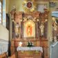 Zdjęcie nr 1: Nastawa ołtarzowa architektoniczna, trójosiowa, jednokondygnacyjna ze zwieńczeniem, na cokole. Mensa skrzyniowa, z antepedium artykułowanym trzema prostokątnymi płycinami, w bocznych rozety, w środkowej krzyż równoramienny. Cokół nastawy siedmiodzielny, z nieparzystymi częściami wysuniętymi przed lico, zdobionymi plakietami ornamentalnymi. Nastawa dzielona kolumnami z opaskami w jednej trzeciej wysokości, o kapitelach utworzonych z elementów roślinnych, podtrzymujących belkowanie wyłamane na ich osiach. W wyłamanych częściach fryzu plakiety dekoracyjne z motywem roślinnym. W polu centralnym nisza z rzeźbą ukrzyżowanego Chrystusa między narzędziami męki, oprawiona w szeroką, profilowaną ramę. Powyżej niej para putt trzymająca kartusz obwiedziony ramą z kwitnących róż z napisem „JEZU / ZMIŁUJ SIĘ / NAD / NAMI”. W polach bocznych ustawione na konsolach i cokołach figury św. Józefa po lewej i św. Joachima (?) po prawej stronie. W partii zwieńczenia urwane fragmenty przyczółka ponad zewnętrznymi fragmentami belkowania, na nich posadowione modlące się postacie. Na środku, w okrągłym polu monogram IHS otoczony obłokami, na tle glorii promienistej. 
Ołtarz marmoryzowany na kolor jasnobrązowy, płyciny na kolor brązowo-żółty, kolumny na ciemnobrązowy. Detale i ornamenty złocone; polichromia w partiach ciała postaci naturalistyczna. 