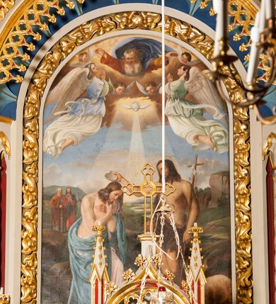 Zdjęcie nr 3: Ołtarz przyścienny z obejściem, złożony z mensy, predelli, bramek i nastawy. Mensa sarkofagowa, z kamiennym blatem, antepedium haftowane w motywy roślinne, z barankiem paschalnym w centrum. Predella dwukondygnacyjna, trójosiowa, osie rozdzielają zdwojone kolumny na wysokich konsolach, wychodzące przed lico predelli. W dolnej partii, części boczne dekorowane płycinami o kształcie zbliżonym do kwadratu, złożone z czworoliści, w polu środkowym prostopadłościenne tabernakulum, z drzwiczkami dekorowanymi groszowaniem i umieszczonym na jego tle motywem zdwojonego łuku ostrego z wpisanym monogramem IHS. Górna kondygnacja predelli oddzielona gzymsem, złożona z trzech zakończonych ostrołukowo blend w centrum i pięciu płycin różnej wysokości w częściach bocznych, flankowana pinaklami. Oś środkowa zakończona łukiem w ośli grzbiet nałożonym na łuk okrągły, zdobionym żabkami i zwieńczona krzyżem, flankowanym pinaklami z żabkami i kwiatonem. Do predelli przylegają z dwóch stron bramki prostokątne, zamknięte od góry łukiem odwróconym i flankowane pinaklem zakończonym kwiatonem. W bramkach wycięty otwór w kształcie prostokąta zamkniętego łukiem pełnym, powyżej którego umieszczono okrągłą plakietę wypełnioną motywem czworoliścia z wpisanymi łukami podkowiastymi. Plakietę ujmuje od góry łuk nadwieszony stykający się w środkowej części ze wspomnianym łukiem odwróconym. Nastawa znajduje się za predellą. Widoczna część składa się z pola flankowanego smukłymi kolumnami o kapitelach utworzonych z motywów roślinnych, na których skośnie ustawiono pinakle zdobione żabkami i zwieńczone kwiatonami. Na kolumnach wspiera się łuk w ośli grzbiet zdobiony od dołu ażurową koronką, a od góry żabkami i zwieńczony krzyżem. Za kolumnami ustawiono niższe, smuklejsze i skręcone, nakryte baldachimami z wyciętymi łukami ostrymi. Pole nastawy wypełnia obraz z przedstawieniem chrztu Chrystusa w kształcie stojącego prostokąta zamkniętego półkoliście w ramie utworzonej z mięsistych liści. 
Powierzchnia ołtarza w kolorze białym, wnętrza płycin czerwone, profile, detale i ornamenty złocone, wnętrze arkady nastawy niebieskie. 