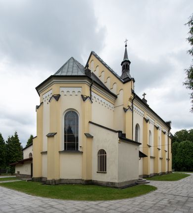 Zdjęcie nr 5: Kościół orientowany, jednonawowy, czteroprzęsłowy z niższym i węższym, jednoprzęsłowym prezbiterium zamkniętym wielobocznie. Od północnego wschodu do prezbiterium i nawy przylega zakrystia na rzucie prostokąta, od południowego wschodu prostokątna kruchta, a od zachodu kolejna prostokątna kruchta. W nawie sklepienie kolebkowe z lunetami, na zdwojonych gurtach przechodzących w pilastry o kompozytowych kapitelach i kanelowanych trzonach; w prezbiterium kolebkowe z lunetami na pojedynczych gurtach. Prezbiterium od nawy wydziela ściana tęczowa otwierająca się do wnętrza półkolistą arkadą. W ostatnim, zachodnim przęśle nawy chór muzyczny o ażurowej balustradzie, wsparty na dwóch smukłych, żeliwnych kolumnach. Otwory okienne w nawie i prezbiterium w kształcie stojącego prostokąta zamkniętego półkoliście. W ścianie zachodniej, w osi elewacji okno okrągłe. Fasada jednokondygnacyjna, jednoosiowa zamknięta trójkątną ścianą szczytową zwieńczoną krzyżem osadzonym na niewielkim daszku. W przyziemiu kruchta z otworem wejściowym w kształcie stojącego prostokąta zamkniętego łukiem półkolistym. Drzwi drewniane, dwuskrzydłowe z nadświetlem. Elewacja kruchty zamknięta schodkową ścianą szczytową zwieńczoną kamiennym krzyżem. Powyżej duże, okrągłe okno wypełnione rozetą, ujęte w motyw półkolistej arkady zaznaczonej w tynku. W górnej części fasady fryz arkadkowy. Elewacje boczne artykułowane uskokowymi przyporami, w górnej części dekorowane fryzem arkadowym. Nad nawą dach dwuspadowy, nad prezbiterium wielopołaciowy, ponad zakrystią oraz obiema kruchtami jednospadowy. Wszystkie kryte blachą. Ponad nawą umieszczona czworoboczna wieżyczka na sygnaturkę, z glorietą zwieńczoną ostrosłupowym hełmem. Na jej szczycie ażurowy krzyż. Elewacje świątyni tynkowane w odcieniach koloru żółtego oraz bieli.