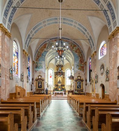 Zdjęcie nr 7: Kościół orientowany, jednonawowy, czteroprzęsłowy z niższym i węższym, jednoprzęsłowym prezbiterium zamkniętym wielobocznie. Od północnego wschodu do prezbiterium i nawy przylega zakrystia na rzucie prostokąta, od południowego wschodu prostokątna kruchta, a od zachodu kolejna prostokątna kruchta. W nawie sklepienie kolebkowe z lunetami, na zdwojonych gurtach przechodzących w pilastry o kompozytowych kapitelach i kanelowanych trzonach; w prezbiterium kolebkowe z lunetami na pojedynczych gurtach. Prezbiterium od nawy wydziela ściana tęczowa otwierająca się do wnętrza półkolistą arkadą. W ostatnim, zachodnim przęśle nawy chór muzyczny o ażurowej balustradzie, wsparty na dwóch smukłych, żeliwnych kolumnach. Otwory okienne w nawie i prezbiterium w kształcie stojącego prostokąta zamkniętego półkoliście. W ścianie zachodniej, w osi elewacji okno okrągłe. Fasada jednokondygnacyjna, jednoosiowa zamknięta trójkątną ścianą szczytową zwieńczoną krzyżem osadzonym na niewielkim daszku. W przyziemiu kruchta z otworem wejściowym w kształcie stojącego prostokąta zamkniętego łukiem półkolistym. Drzwi drewniane, dwuskrzydłowe z nadświetlem. Elewacja kruchty zamknięta schodkową ścianą szczytową zwieńczoną kamiennym krzyżem. Powyżej duże, okrągłe okno wypełnione rozetą, ujęte w motyw półkolistej arkady zaznaczonej w tynku. W górnej części fasady fryz arkadkowy. Elewacje boczne artykułowane uskokowymi przyporami, w górnej części dekorowane fryzem arkadowym. Nad nawą dach dwuspadowy, nad prezbiterium wielopołaciowy, ponad zakrystią oraz obiema kruchtami jednospadowy. Wszystkie kryte blachą. Ponad nawą umieszczona czworoboczna wieżyczka na sygnaturkę, z glorietą zwieńczoną ostrosłupowym hełmem. Na jej szczycie ażurowy krzyż. Elewacje świątyni tynkowane w odcieniach koloru żółtego oraz bieli.