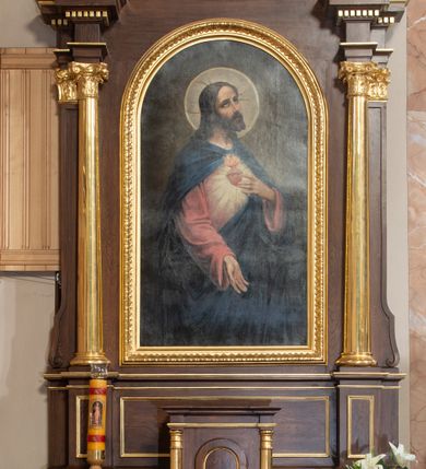 Zdjęcie nr 2: Ołtarz przyścienny, architektoniczny, jednoosiowy, jednokondygnacyjny ze zwieńczeniem. Mensa prostopadłościenna z kamiennym portatylem, zamknięta wydatnym, profilowanym gzymsem wspartym na dwóch parach złoconych półkolumn. Pośrodku antepedium czworolistne, srebrzone i złocone pole z monogramem IHS i czterema gwiazdami. Tabernakulum prostopadłościenne, ujęte złoconymi kolumienkami dźwigającymi profilowany gzyms. Drzwiczki w kształcie stojącego prostokąta zamkniętego półkoliście. Retabulum ujęte parą złoconych kolumn korynckich ustawionych na tle pary pilastrów w dolnej części trzonu przechodzących w woluty. Podpory ustawione na cokole wspierają odcinki wyłamanego belkowania, na którym ustawione są złocone wazony. W partii gzymsu złocone kostkowanie. Zwieńczenie ujęte akantowymi spływami wolutowymi; pośrodku owalne pole ze złoconym monogramem IHS umieszczonym na srebrzonym tle. Zwieńczenie zamknięte profilowanym gzymsem wyginającym się w kształt łuku nadwieszonego i umieszczonym w osi ołtarza krzyżem o trójlistnych zakończeniach ramion. W polu głównym ołtarza obraz z przedstawieniem Najświętszego Serca Jezusa ujęty prostokątną, profilowaną ramą zamkniętą łukiem półkolistym. Cokół nastawy dekorowany rzeźbionym ornamentem roślinnym. Całość struktury ołtarza lakierowana w odcieniu ciemnobrązowym, detal architektoniczny pozłacany i posrebrzany.
