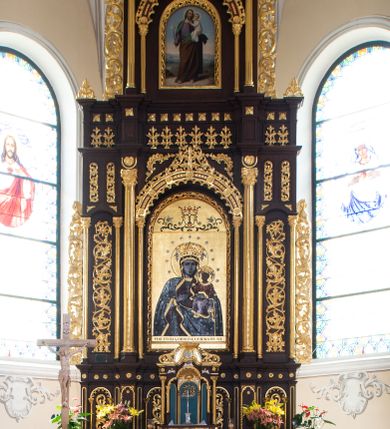 Zdjęcie nr 1: Ołtarz architektoniczny, trójosiowy, dwukondygnacyjny ze zwieńczeniem, ujęty ażurowymi uszami utworzonymi z akantu oraz wstęgi regencyjnej. Mensa prostopadłościenna; antepedium drewniane z dekoracją płycinową, artykułowane pilastrami o kanelowanych trzonach. Centralna płycina w kształcie stojącego prostokąta zamkniętego od góry i dołu łukiem wyniesionym; w jej wnętrzu złocony krzyż. Tabernakulum dwukondygnacyjne, jednodrzwiczkowe z tronem wystawienia ujętym złoconymi kolumienkami dźwigającymi srebrzony baldachim w formie kopuły flankowanej akantowymi wolutami. Arkada ujmująca tron wystawienia o wykroju trójliścia, w podniebiu dekorowana złoconą muszą palmetową, poniżej której złocony monogram IHS na niebieskim tle. Drzwiczki tabernakulum złocone z umieszczonym centralnie kielichem z hostią ujętym płyciną w kształcie stojącego prostokąta zamkniętego półkoliście. Nastawa na wysokim, dwukondygnacyjnym cokole o podziałach architektonicznych. Kondygnacja druga artykułowana zwielokrotnionymi pilastrami o trzonach dekorowanych maswerkiem, pomiędzy którymi półkoliste arkadki wypełnione akantem, ujęte wąskimi, złoconymi kolumienkami. Cokół zwieńczony fryzem dekorowanym rozetkami i profilowanym gzymsem. W polu głównym ołtarza nisza w kształcie stojącego prostokąta zamkniętego łukiem półkolistym ujęta smukłymi, złoconymi kolumienkami wspierającymi bogato dekorowaną ornamentem roślinnym, kostkowaniem i rozetkami arkadę. W polu obraz przedstawiający Matkę Boską z Dzieciątkiem na złoconym tle. Oś środkowa ołtarza wyższa i szersza od bocznych, ujęta złoconymi kolumnami o korynckich kapitelach dźwigających pełne, wyłamane na osiach kolumn, belkowanie. Fryz dekorowany liśćmi akantu oraz rozetkami. Osie boczne ujęte mniejszymi, złoconymi kolumienkami, dźwigającymi półkolisty łuk. W niszach pomiędzy nimi złocona, dekoracja akantowa o pasowym przebiegu. Kondygnacja druga ujęta złoconymi kolumienkami o korynckich kapitelach oraz ażurowymi uszami utworzonymi z akantu oraz wstęgi regencyjnej, zwieńczona równoramiennym krzyżem dekorowanym rozetkami. W polu obraz w kształcie stojącego prostokąta przedstawiający św. Józefa z Dzieciątkiem Jezus. Obraz ujęty półkolistą arkadą bogato dekorowaną ornamentem roślinnym, rozetkami oraz fryzem arkadkowym, wspartą na smukłych, złoconych kolumienkach. Struktura ołtarza malowana w kolorze ciemnobrązowym, ornamentyka oraz detale elementów architektonicznych złocone.