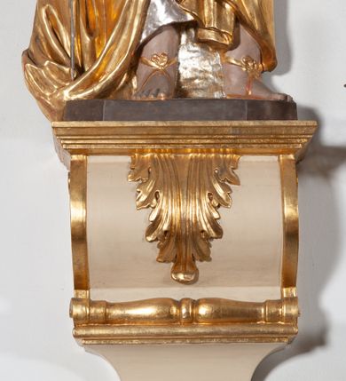 Zdjęcie nr 4: Całopostaciowa, ustawiona na konsoli w formie spływu wolutowego figura przedstawia zwróconą na wprost postać św. Pawła stojącego w lekkim kontrapoście. Pociągłą twarz charakteryzuje długi, ciemnobrązowy zarost, niewielkie, szeroko otwarte oczy wzniesione brwi oraz długi, prosty nos. Włosy są krótkie, ciemnobrązowe, kręcone. Święty ubrany jest w srebrzoną suknię z długimi rękawami oraz osłaniający niemal całą sylwetkę, wydatnie fałdowany złocony płaszcz, na stopach są złocone sandały. Prawą, opuszczoną w dół ręką podtrzymuje wsparty na pole płaszcza miecz, w lewej ma księgę w czerwonej oprawie. 