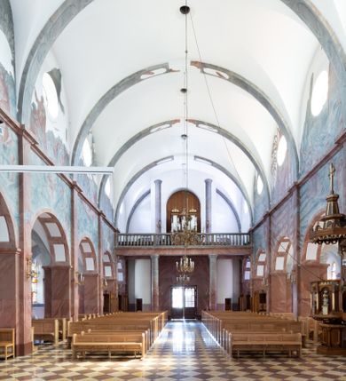 Zdjęcie nr 7: Trójnawowa, czteroprzęsłowa bazylika filarowa, z jednoprzęsłowym, zakończonym wielobocznie prezbiterium, przy którym od południa prostokątna zakrystia; od zachodu na osi wieża na rzucie kwadratu, z kruchtą w przyziemiu, częściowo wtopiona w korpus nawowy. Arkady międzynawowe i tęcza zamknięte półkoliście. Sklepienia kolebkowe z lunetami. Okna prostokątne zamknięte półkoliście, w nawie głównej, ponad arkadami międzynawowymi, okulusy. Fasada pięcioosiowa, pośrodku z ryzalitem wieży występującej przed lico elewacji nawy głównej i naw bocznych, w których zamknięte półkoliście otwory wejściowe. Wieża czterokondygnacyjna, nakryta ostrosłupowym, wysokim hełmem. Zakończenie prezbiterium opięte przyporami. Dachy dwuspadowe na nawą główną i prezbiterium, pulpitowe nad nawami bocznymi. 