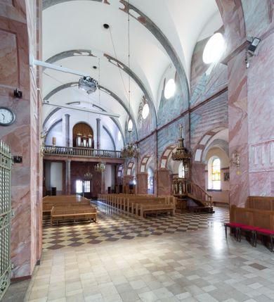 Zdjęcie nr 10: Trójnawowa, czteroprzęsłowa bazylika filarowa, z jednoprzęsłowym, zakończonym wielobocznie prezbiterium, przy którym od południa prostokątna zakrystia; od zachodu na osi wieża na rzucie kwadratu, z kruchtą w przyziemiu, częściowo wtopiona w korpus nawowy. Arkady międzynawowe i tęcza zamknięte półkoliście. Sklepienia kolebkowe z lunetami. Okna prostokątne zamknięte półkoliście, w nawie głównej, ponad arkadami międzynawowymi, okulusy. Fasada pięcioosiowa, pośrodku z ryzalitem wieży występującej przed lico elewacji nawy głównej i naw bocznych, w których zamknięte półkoliście otwory wejściowe. Wieża czterokondygnacyjna, nakryta ostrosłupowym, wysokim hełmem. Zakończenie prezbiterium opięte przyporami. Dachy dwuspadowe na nawą główną i prezbiterium, pulpitowe nad nawami bocznymi. 