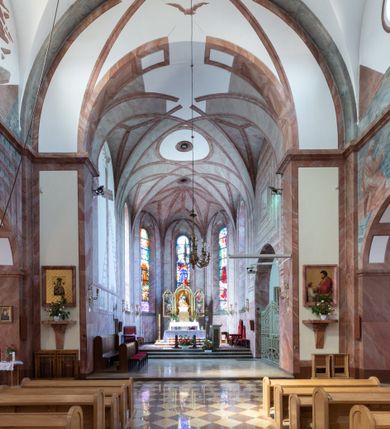 Zdjęcie nr 21: Trójnawowa, czteroprzęsłowa bazylika filarowa, z jednoprzęsłowym, zakończonym wielobocznie prezbiterium, przy którym od południa prostokątna zakrystia; od zachodu na osi wieża na rzucie kwadratu, z kruchtą w przyziemiu, częściowo wtopiona w korpus nawowy. Arkady międzynawowe i tęcza zamknięte półkoliście. Sklepienia kolebkowe z lunetami. Okna prostokątne zamknięte półkoliście, w nawie głównej, ponad arkadami międzynawowymi, okulusy. Fasada pięcioosiowa, pośrodku z ryzalitem wieży występującej przed lico elewacji nawy głównej i naw bocznych, w których zamknięte półkoliście otwory wejściowe. Wieża czterokondygnacyjna, nakryta ostrosłupowym, wysokim hełmem. Zakończenie prezbiterium opięte przyporami. Dachy dwuspadowe na nawą główną i prezbiterium, pulpitowe nad nawami bocznymi. 