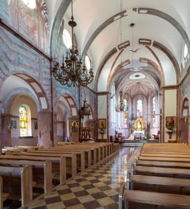 Zdjęcie nr 4: Trójnawowa, czteroprzęsłowa bazylika filarowa, z jednoprzęsłowym, zakończonym wielobocznie prezbiterium, przy którym od południa prostokątna zakrystia; od zachodu na osi wieża na rzucie kwadratu, z kruchtą w przyziemiu, częściowo wtopiona w korpus nawowy. Arkady międzynawowe i tęcza zamknięte półkoliście. Sklepienia kolebkowe z lunetami. Okna prostokątne zamknięte półkoliście, w nawie głównej, ponad arkadami międzynawowymi, okulusy. Fasada pięcioosiowa, pośrodku z ryzalitem wieży występującej przed lico elewacji nawy głównej i naw bocznych, w których zamknięte półkoliście otwory wejściowe. Wieża czterokondygnacyjna, nakryta ostrosłupowym, wysokim hełmem. Zakończenie prezbiterium opięte przyporami. Dachy dwuspadowe na nawą główną i prezbiterium, pulpitowe nad nawami bocznymi. 