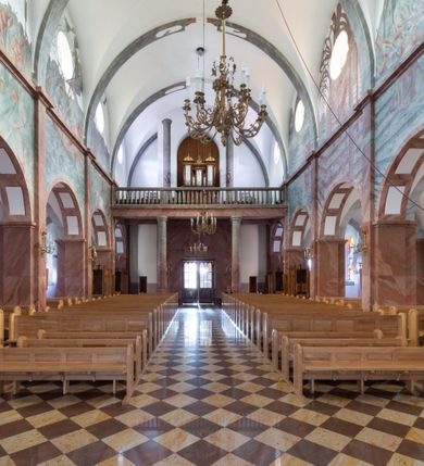 Zdjęcie nr 6: Trójnawowa, czteroprzęsłowa bazylika filarowa, z jednoprzęsłowym, zakończonym wielobocznie prezbiterium, przy którym od południa prostokątna zakrystia; od zachodu na osi wieża na rzucie kwadratu, z kruchtą w przyziemiu, częściowo wtopiona w korpus nawowy. Arkady międzynawowe i tęcza zamknięte półkoliście. Sklepienia kolebkowe z lunetami. Okna prostokątne zamknięte półkoliście, w nawie głównej, ponad arkadami międzynawowymi, okulusy. Fasada pięcioosiowa, pośrodku z ryzalitem wieży występującej przed lico elewacji nawy głównej i naw bocznych, w których zamknięte półkoliście otwory wejściowe. Wieża czterokondygnacyjna, nakryta ostrosłupowym, wysokim hełmem. Zakończenie prezbiterium opięte przyporami. Dachy dwuspadowe na nawą główną i prezbiterium, pulpitowe nad nawami bocznymi. 