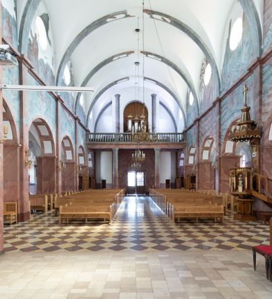 Zdjęcie nr 5: Trójnawowa, czteroprzęsłowa bazylika filarowa, z jednoprzęsłowym, zakończonym wielobocznie prezbiterium, przy którym od południa prostokątna zakrystia; od zachodu na osi wieża na rzucie kwadratu, z kruchtą w przyziemiu, częściowo wtopiona w korpus nawowy. Arkady międzynawowe i tęcza zamknięte półkoliście. Sklepienia kolebkowe z lunetami. Okna prostokątne zamknięte półkoliście, w nawie głównej, ponad arkadami międzynawowymi, okulusy. Fasada pięcioosiowa, pośrodku z ryzalitem wieży występującej przed lico elewacji nawy głównej i naw bocznych, w których zamknięte półkoliście otwory wejściowe. Wieża czterokondygnacyjna, nakryta ostrosłupowym, wysokim hełmem. Zakończenie prezbiterium opięte przyporami. Dachy dwuspadowe na nawą główną i prezbiterium, pulpitowe nad nawami bocznymi. 