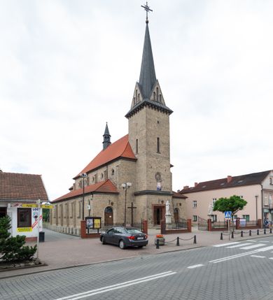 Zdjęcie nr 2: Trójnawowa, czteroprzęsłowa bazylika filarowa, z jednoprzęsłowym, zakończonym wielobocznie prezbiterium, przy którym od południa prostokątna zakrystia; od zachodu na osi wieża na rzucie kwadratu, z kruchtą w przyziemiu, częściowo wtopiona w korpus nawowy. Arkady międzynawowe i tęcza zamknięte półkoliście. Sklepienia kolebkowe z lunetami. Okna prostokątne zamknięte półkoliście, w nawie głównej, ponad arkadami międzynawowymi, okulusy. Fasada pięcioosiowa, pośrodku z ryzalitem wieży występującej przed lico elewacji nawy głównej i naw bocznych, w których zamknięte półkoliście otwory wejściowe. Wieża czterokondygnacyjna, nakryta ostrosłupowym, wysokim hełmem. Zakończenie prezbiterium opięte przyporami. Dachy dwuspadowe na nawą główną i prezbiterium, pulpitowe nad nawami bocznymi. 