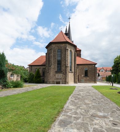 Zdjęcie nr 12: Trójnawowa, czteroprzęsłowa bazylika filarowa, z jednoprzęsłowym, zakończonym wielobocznie prezbiterium, przy którym od południa prostokątna zakrystia; od zachodu na osi wieża na rzucie kwadratu, z kruchtą w przyziemiu, częściowo wtopiona w korpus nawowy. Arkady międzynawowe i tęcza zamknięte półkoliście. Sklepienia kolebkowe z lunetami. Okna prostokątne zamknięte półkoliście, w nawie głównej, ponad arkadami międzynawowymi, okulusy. Fasada pięcioosiowa, pośrodku z ryzalitem wieży występującej przed lico elewacji nawy głównej i naw bocznych, w których zamknięte półkoliście otwory wejściowe. Wieża czterokondygnacyjna, nakryta ostrosłupowym, wysokim hełmem. Zakończenie prezbiterium opięte przyporami. Dachy dwuspadowe na nawą główną i prezbiterium, pulpitowe nad nawami bocznymi. 