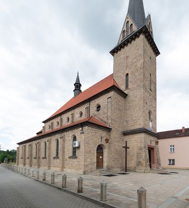 Zdjęcie nr 11: Trójnawowa, czteroprzęsłowa bazylika filarowa, z jednoprzęsłowym, zakończonym wielobocznie prezbiterium, przy którym od południa prostokątna zakrystia; od zachodu na osi wieża na rzucie kwadratu, z kruchtą w przyziemiu, częściowo wtopiona w korpus nawowy. Arkady międzynawowe i tęcza zamknięte półkoliście. Sklepienia kolebkowe z lunetami. Okna prostokątne zamknięte półkoliście, w nawie głównej, ponad arkadami międzynawowymi, okulusy. Fasada pięcioosiowa, pośrodku z ryzalitem wieży występującej przed lico elewacji nawy głównej i naw bocznych, w których zamknięte półkoliście otwory wejściowe. Wieża czterokondygnacyjna, nakryta ostrosłupowym, wysokim hełmem. Zakończenie prezbiterium opięte przyporami. Dachy dwuspadowe na nawą główną i prezbiterium, pulpitowe nad nawami bocznymi. 