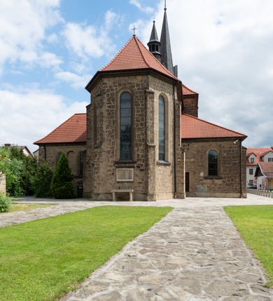 Zdjęcie nr 13: Trójnawowa, czteroprzęsłowa bazylika filarowa, z jednoprzęsłowym, zakończonym wielobocznie prezbiterium, przy którym od południa prostokątna zakrystia; od zachodu na osi wieża na rzucie kwadratu, z kruchtą w przyziemiu, częściowo wtopiona w korpus nawowy. Arkady międzynawowe i tęcza zamknięte półkoliście. Sklepienia kolebkowe z lunetami. Okna prostokątne zamknięte półkoliście, w nawie głównej, ponad arkadami międzynawowymi, okulusy. Fasada pięcioosiowa, pośrodku z ryzalitem wieży występującej przed lico elewacji nawy głównej i naw bocznych, w których zamknięte półkoliście otwory wejściowe. Wieża czterokondygnacyjna, nakryta ostrosłupowym, wysokim hełmem. Zakończenie prezbiterium opięte przyporami. Dachy dwuspadowe na nawą główną i prezbiterium, pulpitowe nad nawami bocznymi. 