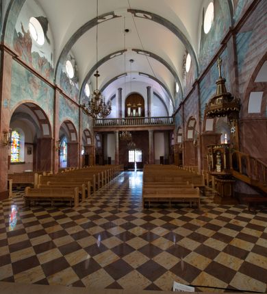 Zdjęcie nr 16: Trójnawowa, czteroprzęsłowa bazylika filarowa, z jednoprzęsłowym, zakończonym wielobocznie prezbiterium, przy którym od południa prostokątna zakrystia; od zachodu na osi wieża na rzucie kwadratu, z kruchtą w przyziemiu, częściowo wtopiona w korpus nawowy. Arkady międzynawowe i tęcza zamknięte półkoliście. Sklepienia kolebkowe z lunetami. Okna prostokątne zamknięte półkoliście, w nawie głównej, ponad arkadami międzynawowymi, okulusy. Fasada pięcioosiowa, pośrodku z ryzalitem wieży występującej przed lico elewacji nawy głównej i naw bocznych, w których zamknięte półkoliście otwory wejściowe. Wieża czterokondygnacyjna, nakryta ostrosłupowym, wysokim hełmem. Zakończenie prezbiterium opięte przyporami. Dachy dwuspadowe na nawą główną i prezbiterium, pulpitowe nad nawami bocznymi. 