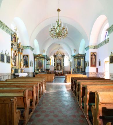 Zdjęcie nr 18: Orientowany, jednonawowy, ścienno- filarowy, z jednoprzęsłowym trójbocznie zamkniętym prezbiterium, po którego bokach zakrystia i kruchta. Od zachodu czworoboczna wieża wtopiona w korpus. Sklepienia kolebkowe, w korpusie na gurtach. Elewacje na cokole, potynkowane. Fasada trójosiowa, pośrodku z płytkim ryzalitem, w którym prostokątny portal, nad nim półkoliste okno, wyżej elewacja wieży ujęta półszczytami.  