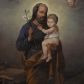 Zdjęcie nr 1: Obraz w kształcie stojącego prostokąta przedstawiający św. Józefa z Dzieciątkiem. Święty został ukazany w całej postaci, delikatnie zwrócony w lewo. Na lewej ręce trzyma Dzieciątko Jezus, a w prawej gałązkę białej lilii. Święty Józef ma podłużną twarz, okoloną krótką brodą oraz ciemnymi włosami, nos długi i wąski, wzrok wpatrzony w Jezusa. Ubrany jest w granatową szatę z długimi rękawami oraz brązowy płaszcz, zarzucony na lewe ramię i opasujący świętego poniżej pasa; stopy bose. Dzieciątko ma twarz o rysach niemowlęcych, wzrok skierowany na widza. Zwrócone jest w trzech czwartych w prawo, ukazane w pozycji siedzącej, z z rączkami opartymi o św. Józefa. Ubrane jest w białą, wąską tkaninę, przerzuconą przez plecy. Wokół głów św. Józefa i Dzieciątka znajdują się złote i świetliste nimby. Całość ukazana w sumarycznie oddanym wnętrzu architektonicznym z warsztatem stolarskim i różnymi narzędziami stolarskimi. U góry obrazu dwie  uskrzydlone główki anielskie na chmurze obłoków. Rama drewniana, profilowana, złocona, od zewnątrz zdobiona kimationem.
