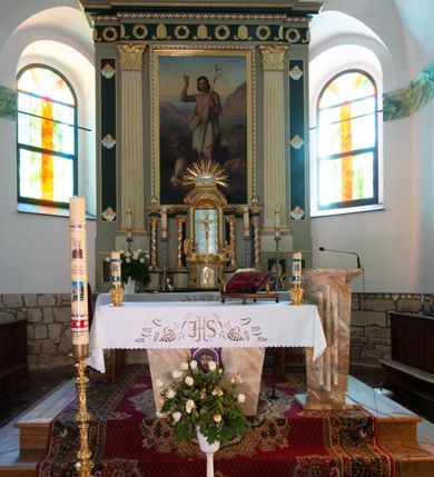Zdjęcie nr 3: Ołtarz architektoniczny, przyścienny, jednokondygnacyjny, jednoosiowy, w formie aediculi. Mensa prostopadłościenna, na niej tabernakulum w formie zbliżonej do prostopadłościennej skrzynki o wypukłej ściance frontowej ustawione na tle ścianki z tronem wystawienia ujętym ramką zamkniętą łukiem nadwieszonym. Drzwiczki tabernakulum dekorowane kielichem z hostią, ujęte wolutami. Tron wystawienia oraz ściankę flankują kręcone kolumny podtrzymujące wyłamane na ich osiach belkowanie. Niszę wypełnia pasyjka na tle kół dekorowanych liliami, po jej dwóch stronach klęczące anioły trzymające kielichy. Tabernakulum polichromowane na kolor jasnoszary, fryz ciemnoszary, profile złocone.
Nastawa na wysokim cokole dekorowanym prostokątnymi płycinami z dekoracją. W polu głównym rama w kształcie stojącego prostokąta, a w niej obraz z przedstawieniem św. Jana Chrzciciela. Pole flankowane zakończonymi kapitelami, kanelowanymi pilastrami podtrzymującymi wyłamane nad polem centralnym belkowanie. Na osiach zewnętrznych prostokątne płyciny. Całość zwieńczona trójkątnym przyczółkiem  z polem wypełnionym wieńcem i glorią promienistą z wiązkami prostych promieni przedzielonymi pojedynczymi, falistymi. Na skrajnych fragmentach belkowania wazony. 
Na zewnętrznych płycinach uskrzydlone aniołki na chmurach, fryz z dekoracją z naprzemiennie umieszczonych wieńców i palmet poniżej perełkowania, krawędzie zwieńczenia podkreślone rzędami listków. 
Struktura w kolorze jasnoszarym, płyciny ciemnoszare, profile, ornamenty i dekoracje złocone i srebrzone.

