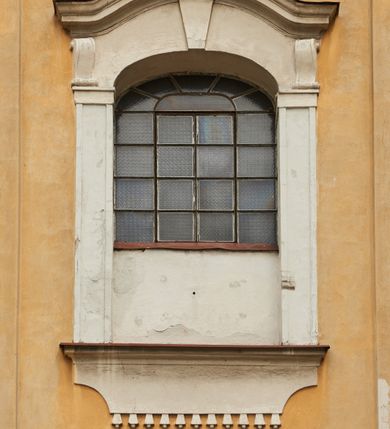 Zdjęcie nr 27: Kościół jest orientowany, murowany z cegły i kamienia, na rzucie podłużnym. Zajmuje powierzchnię około 606 metrów kwadratowych, długość bryły wynosi około 32, a szerokość 14 metrów. Jednonawowy, trójprzęsłowy korpus charakteryzuje środkowe, kwadratowe przęsło z płytkimi apsydami po bokach, wysuwającymi się przed lica elewacji bocznych, na wzór pseudotranseptu (para spłaszczonych apsyd). Przęsło wschodnie, na rzucie prostokąta, z wnękami po bokach, zakończone jest apsydą stanowiącą przestrzeń prezbiterium. Na osi kościoła i przedłużeniu prezbiterium jest piętrowa zakrystia ze skarbcem, natomiast w przedłużeniu przęsła zachodniego wieża ujęta po bokach piętrowymi lokalnościami. Korpus nawowy przekryty jest sklepieniem kolebkowym na gurtach, z lunetami, które w przęśle środkowym, na przecięciu z pseudotranseptem, tworzy rodzaj sklepienia krzyżowego z okrągłym zwierciadłem. Artykulację ścian wewnątrz kościoła stanowią pary pilastrów wspierające przerywane belkowanie. Na zewnątrz ściany korpusu, transeptu i zakrystii artykułują osadzone na niewysokim cokole lizeny wspierające obiegające całość belkowanie. Dodatkowo mury przeprute są owalnymi otworami okiennymi ujętymi profilowanymi obramieniami. Fasadę charakteryzuje w części środkowej ryzalit o skośnych ściankach bocznych oraz podziały podwójnymi i pojedynczymi pilastrami jońskimi, osadzonymi na wysokich cokołach i wspierającymi belkowanie. Do wnętrza kościoła prowadzą trzy otwory drzwiowe – w elewacji południowej, północnej i zachodniej. Drzwi w fasadzie są ujęte dekoracyjnym portalem z parą wąskich pilastrów, zwieńczonych zwężającymi się ku dołowi kapitelami, wspierających gzyms w formie łuku odcinkowego. Całość ujmuje obramienie o fantazyjnym wykroju w górnej partii, którego krawędzie obiega profilowana listwa z parą niewielkich wolut w górnych narożach. Obramienie drzwi wieńczy prosty gzyms odcinkowy nakryty blaszanym daszkiem. Po bokach wejścia znajduje się para kamiennych kropielnic. Powyżej otworu drzwiowego, pole środkowe fasady przeprute zostało oknem w kształcie stojącego prostokąta zamkniętego łukiem odcinkowym, zamurowanego w jednej trzeciej wysokości. Obramienie okna jest w formie pary pilastrów bez baz, wspierających fryz z kluczem pośrodku i parą wsporników wolutowych po bokach, dźwigających odcinkowy gzyms wieńczący. Pod parapetem umieszczono fartuch w kształcie leżącego prostokąta, o wklęsłych dolnych narożach, z dolną krawędzią zdobioną motywem lambrekinu. W skośnych ścianach bocznych ryzalitu znajduje się para zamkniętych półkoliście niszy z figurami św. Piotra po lewej i św. Pawła po prawej stronie. 
Ryzalit wieńczy trójkątny przyczółek z herbem Nowina w tympanonie. Nad belkowaniem, na całej szerokości fasady, znajduje się prosta attyka z odpowiadającymi dolnej strefie elewacji podziałami lizenowymi, wspierającymi wyłamujący się ponad nimi gzyms ozdobiony wazonami. Powyżej wznosi się górne piętro wieży, czworościenne o ściętych narożnikach, nakryte kopulastym hełmem z nasadnikiem.  
Północna, zachodnia i południowa ściana wieży przeprute są otworami okiennymi w kształcie stojącego prostokąta zamkniętego łukiem odcinkowym. Okna mają obramienia w kształcie stojących prostokątów z uszakami w górnych narożach, zwieńczone są belkowaniem w formie łuku odcinkowego z kluczem pośrodku i parą wolutowych wsporników po bokach fryzu. Podwieszenie ma formę fartucha w kształcie leżącego prostokąta o wklęsłych dolnych narożach i dolnej krawędzi zdobionej motywem lambrekinu. Powyżej otworów okiennych znajdują się okrągłe tarcze zegarowe. Pola ściętych naroży wieży zdobi ornamentyka cekinowa i kampanule. Korpus nawowy przykrywa dwuspadowy dach zakończony pięciopołaciowo nad prezbiterium i trójpołaciowo nad końcami transeptu, kryty dachówką. Na skrzyżowaniu korpusu nawowego i transeptu ulokowano obitą blachą wieżyczkę na sygnaturkę. Kolorystyka tynków kościoła utrzymana jest w odcieniu ugru, w dolnej partii różu, detal architektoniczny i ornamentyka w bieli. 

Plac przykościelny otoczony jest murowanym parkanem z usytuowanymi w nim 14 kapliczkami ze stacjami drogi krzyżowej, nakrytymi dwuspadowymi dachami. W jednym z naroży znajduje się niewielka, murowana kaplica grobowa rodziny Romerów o ceglanych ścianach artykułowanych białymi pilastrami i fasadzie ze szczytem ujętym parą spływów i zwieńczonym trójkątnym przyczółkiem.   
