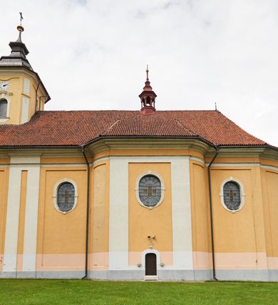 Zdjęcie nr 19: Kościół jest orientowany, murowany z cegły i kamienia, na rzucie podłużnym. Zajmuje powierzchnię około 606 metrów kwadratowych, długość bryły wynosi około 32, a szerokość 14 metrów. Jednonawowy, trójprzęsłowy korpus charakteryzuje środkowe, kwadratowe przęsło z płytkimi apsydami po bokach, wysuwającymi się przed lica elewacji bocznych, na wzór pseudotranseptu (para spłaszczonych apsyd). Przęsło wschodnie, na rzucie prostokąta, z wnękami po bokach, zakończone jest apsydą stanowiącą przestrzeń prezbiterium. Na osi kościoła i przedłużeniu prezbiterium jest piętrowa zakrystia ze skarbcem, natomiast w przedłużeniu przęsła zachodniego wieża ujęta po bokach piętrowymi lokalnościami. Korpus nawowy przekryty jest sklepieniem kolebkowym na gurtach, z lunetami, które w przęśle środkowym, na przecięciu z pseudotranseptem, tworzy rodzaj sklepienia krzyżowego z okrągłym zwierciadłem. Artykulację ścian wewnątrz kościoła stanowią pary pilastrów wspierające przerywane belkowanie. Na zewnątrz ściany korpusu, transeptu i zakrystii artykułują osadzone na niewysokim cokole lizeny wspierające obiegające całość belkowanie. Dodatkowo mury przeprute są owalnymi otworami okiennymi ujętymi profilowanymi obramieniami. Fasadę charakteryzuje w części środkowej ryzalit o skośnych ściankach bocznych oraz podziały podwójnymi i pojedynczymi pilastrami jońskimi, osadzonymi na wysokich cokołach i wspierającymi belkowanie. Do wnętrza kościoła prowadzą trzy otwory drzwiowe – w elewacji południowej, północnej i zachodniej. Drzwi w fasadzie są ujęte dekoracyjnym portalem z parą wąskich pilastrów, zwieńczonych zwężającymi się ku dołowi kapitelami, wspierających gzyms w formie łuku odcinkowego. Całość ujmuje obramienie o fantazyjnym wykroju w górnej partii, którego krawędzie obiega profilowana listwa z parą niewielkich wolut w górnych narożach. Obramienie drzwi wieńczy prosty gzyms odcinkowy nakryty blaszanym daszkiem. Po bokach wejścia znajduje się para kamiennych kropielnic. Powyżej otworu drzwiowego, pole środkowe fasady przeprute zostało oknem w kształcie stojącego prostokąta zamkniętego łukiem odcinkowym, zamurowanego w jednej trzeciej wysokości. Obramienie okna jest w formie pary pilastrów bez baz, wspierających fryz z kluczem pośrodku i parą wsporników wolutowych po bokach, dźwigających odcinkowy gzyms wieńczący. Pod parapetem umieszczono fartuch w kształcie leżącego prostokąta, o wklęsłych dolnych narożach, z dolną krawędzią zdobioną motywem lambrekinu. W skośnych ścianach bocznych ryzalitu znajduje się para zamkniętych półkoliście niszy z figurami św. Piotra po lewej i św. Pawła po prawej stronie. 
Ryzalit wieńczy trójkątny przyczółek z herbem Nowina w tympanonie. Nad belkowaniem, na całej szerokości fasady, znajduje się prosta attyka z odpowiadającymi dolnej strefie elewacji podziałami lizenowymi, wspierającymi wyłamujący się ponad nimi gzyms ozdobiony wazonami. Powyżej wznosi się górne piętro wieży, czworościenne o ściętych narożnikach, nakryte kopulastym hełmem z nasadnikiem.  
Północna, zachodnia i południowa ściana wieży przeprute są otworami okiennymi w kształcie stojącego prostokąta zamkniętego łukiem odcinkowym. Okna mają obramienia w kształcie stojących prostokątów z uszakami w górnych narożach, zwieńczone są belkowaniem w formie łuku odcinkowego z kluczem pośrodku i parą wolutowych wsporników po bokach fryzu. Podwieszenie ma formę fartucha w kształcie leżącego prostokąta o wklęsłych dolnych narożach i dolnej krawędzi zdobionej motywem lambrekinu. Powyżej otworów okiennych znajdują się okrągłe tarcze zegarowe. Pola ściętych naroży wieży zdobi ornamentyka cekinowa i kampanule. Korpus nawowy przykrywa dwuspadowy dach zakończony pięciopołaciowo nad prezbiterium i trójpołaciowo nad końcami transeptu, kryty dachówką. Na skrzyżowaniu korpusu nawowego i transeptu ulokowano obitą blachą wieżyczkę na sygnaturkę. Kolorystyka tynków kościoła utrzymana jest w odcieniu ugru, w dolnej partii różu, detal architektoniczny i ornamentyka w bieli. 

Plac przykościelny otoczony jest murowanym parkanem z usytuowanymi w nim 14 kapliczkami ze stacjami drogi krzyżowej, nakrytymi dwuspadowymi dachami. W jednym z naroży znajduje się niewielka, murowana kaplica grobowa rodziny Romerów o ceglanych ścianach artykułowanych białymi pilastrami i fasadzie ze szczytem ujętym parą spływów i zwieńczonym trójkątnym przyczółkiem.   
