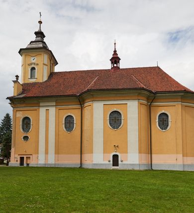 Zdjęcie nr 21: Kościół jest orientowany, murowany z cegły i kamienia, na rzucie podłużnym. Zajmuje powierzchnię około 606 metrów kwadratowych, długość bryły wynosi około 32, a szerokość 14 metrów. Jednonawowy, trójprzęsłowy korpus charakteryzuje środkowe, kwadratowe przęsło z płytkimi apsydami po bokach, wysuwającymi się przed lica elewacji bocznych, na wzór pseudotranseptu (para spłaszczonych apsyd). Przęsło wschodnie, na rzucie prostokąta, z wnękami po bokach, zakończone jest apsydą stanowiącą przestrzeń prezbiterium. Na osi kościoła i przedłużeniu prezbiterium jest piętrowa zakrystia ze skarbcem, natomiast w przedłużeniu przęsła zachodniego wieża ujęta po bokach piętrowymi lokalnościami. Korpus nawowy przekryty jest sklepieniem kolebkowym na gurtach, z lunetami, które w przęśle środkowym, na przecięciu z pseudotranseptem, tworzy rodzaj sklepienia krzyżowego z okrągłym zwierciadłem. Artykulację ścian wewnątrz kościoła stanowią pary pilastrów wspierające przerywane belkowanie. Na zewnątrz ściany korpusu, transeptu i zakrystii artykułują osadzone na niewysokim cokole lizeny wspierające obiegające całość belkowanie. Dodatkowo mury przeprute są owalnymi otworami okiennymi ujętymi profilowanymi obramieniami. Fasadę charakteryzuje w części środkowej ryzalit o skośnych ściankach bocznych oraz podziały podwójnymi i pojedynczymi pilastrami jońskimi, osadzonymi na wysokich cokołach i wspierającymi belkowanie. Do wnętrza kościoła prowadzą trzy otwory drzwiowe – w elewacji południowej, północnej i zachodniej. Drzwi w fasadzie są ujęte dekoracyjnym portalem z parą wąskich pilastrów, zwieńczonych zwężającymi się ku dołowi kapitelami, wspierających gzyms w formie łuku odcinkowego. Całość ujmuje obramienie o fantazyjnym wykroju w górnej partii, którego krawędzie obiega profilowana listwa z parą niewielkich wolut w górnych narożach. Obramienie drzwi wieńczy prosty gzyms odcinkowy nakryty blaszanym daszkiem. Po bokach wejścia znajduje się para kamiennych kropielnic. Powyżej otworu drzwiowego, pole środkowe fasady przeprute zostało oknem w kształcie stojącego prostokąta zamkniętego łukiem odcinkowym, zamurowanego w jednej trzeciej wysokości. Obramienie okna jest w formie pary pilastrów bez baz, wspierających fryz z kluczem pośrodku i parą wsporników wolutowych po bokach, dźwigających odcinkowy gzyms wieńczący. Pod parapetem umieszczono fartuch w kształcie leżącego prostokąta, o wklęsłych dolnych narożach, z dolną krawędzią zdobioną motywem lambrekinu. W skośnych ścianach bocznych ryzalitu znajduje się para zamkniętych półkoliście niszy z figurami św. Piotra po lewej i św. Pawła po prawej stronie. 
Ryzalit wieńczy trójkątny przyczółek z herbem Nowina w tympanonie. Nad belkowaniem, na całej szerokości fasady, znajduje się prosta attyka z odpowiadającymi dolnej strefie elewacji podziałami lizenowymi, wspierającymi wyłamujący się ponad nimi gzyms ozdobiony wazonami. Powyżej wznosi się górne piętro wieży, czworościenne o ściętych narożnikach, nakryte kopulastym hełmem z nasadnikiem.  
Północna, zachodnia i południowa ściana wieży przeprute są otworami okiennymi w kształcie stojącego prostokąta zamkniętego łukiem odcinkowym. Okna mają obramienia w kształcie stojących prostokątów z uszakami w górnych narożach, zwieńczone są belkowaniem w formie łuku odcinkowego z kluczem pośrodku i parą wolutowych wsporników po bokach fryzu. Podwieszenie ma formę fartucha w kształcie leżącego prostokąta o wklęsłych dolnych narożach i dolnej krawędzi zdobionej motywem lambrekinu. Powyżej otworów okiennych znajdują się okrągłe tarcze zegarowe. Pola ściętych naroży wieży zdobi ornamentyka cekinowa i kampanule. Korpus nawowy przykrywa dwuspadowy dach zakończony pięciopołaciowo nad prezbiterium i trójpołaciowo nad końcami transeptu, kryty dachówką. Na skrzyżowaniu korpusu nawowego i transeptu ulokowano obitą blachą wieżyczkę na sygnaturkę. Kolorystyka tynków kościoła utrzymana jest w odcieniu ugru, w dolnej partii różu, detal architektoniczny i ornamentyka w bieli. 

Plac przykościelny otoczony jest murowanym parkanem z usytuowanymi w nim 14 kapliczkami ze stacjami drogi krzyżowej, nakrytymi dwuspadowymi dachami. W jednym z naroży znajduje się niewielka, murowana kaplica grobowa rodziny Romerów o ceglanych ścianach artykułowanych białymi pilastrami i fasadzie ze szczytem ujętym parą spływów i zwieńczonym trójkątnym przyczółkiem.   
