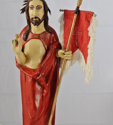 Zdjęcie nr 2: Figura pełnoplastyczna ustawiona na podstawie na planie kwadratu oraz na półkuli. Chrystus stoi frontalnie, w kontrapoście, w lewej ręce trzyma drzewce chorągwi zakończone krzyżem, prawą unosi w geście błogosławieństwa. Jego twarz jest pociągła, o długim, prostym nosie, migdałowatych oczach i niewielkich ustach, okolona krótką brodą i długimi włosami opadającymi na ramiona i plecy. Z tyłu  jego głowy jest dosztukowany nimb promienisty. Chrystus ubrany jest w czerwony płaszcz odsłaniający tors, zapięty na piersi, mocno pofałdowany na wysokości bioder, otaczający postać i przerzucony przez lewe przedramię. Polichromia naturalistyczna, drzewce chorągwi pozłacane.