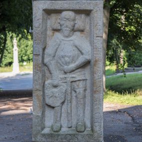 Zdjęcie nr 1: Płyta ma kształt stojącego prostokąta z wydatnym obramieniem, okalającym płaskorzeźbioną postać mężczyzny z odkrytą głową spoczywającą na poduszce. Twarz zmarłego okala zarost. Ma na sobie założoną renesansową zbroję rycerską. W prawej ręce trzyma tarczę z mało czytelnym herbem Orla II (Sasowskie, Szasoroskie), a w lewej miecz ostrzem skierowanym ku dołowi. Na obramieniu częściowo zatarta inskrypcja „HIC IACET GENEROSVS IACOBVS S[A]SOVIVS M[...] [AN]NO [...] 15[46]”.