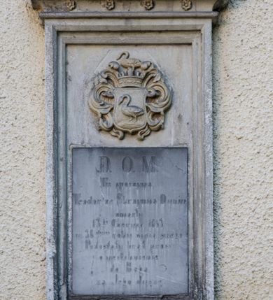 Zdjęcie nr 1: Epitafium w kształcie stojącego prostokąta wsparte na wysuniętym do przodu gzymsie, obwiedzione profilowanym obramieniem, zwieńczone krenelażem wypełnionym ślepym maswerkowaniem i rozetkami. W polu płyty, nad tablicą inskrypcyjną tarcza z godłem herbu Łabędź, labrami, koroną i klejnotem. Poniżej inskrypcja „D(EO) O(PTIMO) M(AXIMO) | Tu spoczywa / Teodor ze Skrzynna Dunin / zmarły 13go czerwca 1853 / w 38mym roku życia swego / pozostały brat prosi / o wstawienie | / do Boga / za Jego duszę”