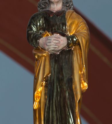 Zdjęcie nr 7: Grupa na tęczy składa się z na wpół ludowo rzeźbionego centralnie krucyfiksu z martwym Chrystusem, po bokach którego stoi pełnorzeźbiona Matka Boska Bolesna i św. Jan Ewangelista. Zbawiciel do krzyża został przymocowany trzema gwoździami. Jezus został ukazany jako martwy z zamkniętymi oczami i głową opadającą na piersi. Jego postać jest wysmukła z nienaturalnie potraktowaną muskulaturą korpusu. Ciało jest wychudzone o zapadłej klatce piersiowej z podkreśloną linią żeber i mostkiem. Z prawej strony widoczny jest przebity bok. Nieznacznie rozchylone nogi są sztywne w kolanach. Prawa stopa założona jest na lewą. Pociągła twarz Chrystusa została miękko opracowana bez szczególnej dbałości o szczegóły anatomiczne. Chrystus ma zamknięte oczy, prosty nos oraz lekko otwarte usta otoczone ciemnobrązowym zarostem, przechodzącym w brodę nieznacznie rozdwojoną na końcu. Jego ciemnobrązowe włosy z lekkim puklowaniem opadają pasmem z prawej strony na ramię, a z lewej na kark, odsłaniając wydatną małżowinę lewego ucha. Chrystus ma na głowie srebrzoną laserunkowo, cierniową koronę, spod której na czoło spływają krople krwi. Krew widoczna jest również na jego rękach, torsie i nogach. Charakterystycznie rzeźbione są nieproporcjonalnie duże dłonie o dwóch zgiętych palcach. Biodra Zbawiciela przepasane są złoconym, krótkim perizonium w formie chusty zawiązanej na duży węzeł z festonem opadającym wzdłuż prawego boku. Ponad głową Chrystusa zawieszony jest titulus w formie tabliczki o faliście wycinanych brzegach ze złotym napisem: „INRI”. 
Stojąca na lekkim wzgórku Matka Boska Bolesna ukazana została w ujęciu trzy czwarte w lewo w nieznacznym kontrapoście. Zgięte w łokciach ręce o nieproporcjonalnie dużych dłoniach ma skrzyżowane na piersi. Maria ma podłużną twarz pozbawioną cech szczególnych. Jej głowę osłania złocona chusta opadająca na ramiona, spod której widoczne są pasma brązowych włosów. Ubrana jest w długą, ciemnoochrową suknię, malowaną laserunkiem, przepasaną w tali oraz płaszcz narzucony na ramiona. Spod sukni widać czubki stóp. 
Święty Jan Ewangelista został zwrócony trzy czwarte w prawo w lekkim kontrapoście. Stojąc na niewielkim wzgórku, trzyma na wysokości brzucha splecione nieproporcjonalnie duże dłonie. Święty ma pociągłą twarz okoloną półdługimi, mocno kręconymi włosami, których pasma z lewej strony odsłaniają wydatną małżowinę uszną. Bardzo mocno zaakcentowano jego krtań. Apostoł ubrany jest w długą tunikę z charakterystycznym kołnierzykiem, malowaną laserunkiem na ciemnooliwkowo oraz złocony płaszcz narzucony na lewe ramię, którego połę zdaje się przyciskać do pasa prawą ręką. Spod tuniki widoczne są czubki stóp. 
Na zachowanym fragmencie oryginalnej belki tęczowej widnieje czerwona inskrypcja: „[...]IT ET IN HONOREN SANCTE MARIE / MAGDALE”. 
