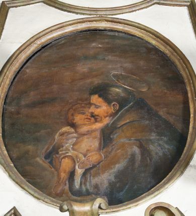 Zdjęcie nr 7: Przyścienne retabulum wznosi się nad sarkofagowym stipesie z drewnianą mensą z kamiennym portatylem, ustawowym na cokole, wspartym na drewnianym podeście. Stipes zwęża się ku dołowi. Od frontu zdobi go fantazyjne obramienie utworzone z profilowanej listwy przechodzącej na środku w płaskorzeźbiony ornament muszlowy. Ponad ołtarzem wznosi się jednoosiowe i jednokondygnacyjne retabulum ze zwieńczeniem ustawione na wysokim cokole. Nastawę artykułuje para zdwojonych pilastrów o korynckich głowicach z trzonami dekorowanymi zawieszonymi na wstęgach festonach owocowo-kwiatowych. Pilastry dźwigają imposty o wyłamanym wklęśle gzymsie, oraz przerwany półkolisty przyczółek. Imposty połączone zostały architrawem nad polem głównym, przyjmującym kształt odwróconego łuku odcinkowego, dekorowanego muszlowym kartuszem z napisem: „ORA PRO NOBIS / SANCTA DEI / GENITRIX”. W polu środkowym umieszczono obraz Matki Boskiej z Dzieciątkiem w formie stojącego prostokąta ujęty profilowaną ramą. Poniżej obrazu znalazła się ramka w formie leżącego prostokąta o wklęsłych bokach. Zwieńczenie uzyskało formę stojącego prostokąta o wklęsłych bokach zamknięty całującymi się wolutami i muszlą. W polu zwieńczenia umieszczono owalny obraz św. Antoniego Padewskiego, ujęty profilowaną ramą. Ponad nim znajdują się dekoracyjne, profilowane listewki układające się w fantazyjne kształty. Po bokach retabulum usytuowano zredukowane uszaki w formie wąskich, ażurowych wici roślinnych. Strukturę nastawy polichromowano na biało, ornamentyka i profile pierwotnie były złocone.