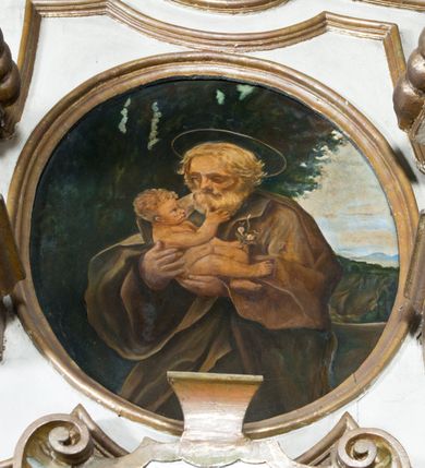 Zdjęcie nr 8: Przyścienne retabulum wznosi się nad sarkofagowym stipesie z drewnianą mensą z kamiennym portatylem, ustawowym na cokole, wspartym na drewnianym podeście. Stipes zwęża się ku dołowi. Od frontu zdobi go fantazyjne obramienie utworzone z profilowanej listwy przechodzącej na środku w płaskorzeźbiony ornament muszlowy. Ponad ołtarzem wznosi się jednoosiowe i jednokondygnacyjne retabulum ze zwieńczeniem ustawione na wysokim cokole. Nastawę artykułuje para zdwojonych pilastrów o korynckich głowicach z trzonami dekorowanymi zawieszonymi na wstęgach festonach owocowo-kwiatowych. Pilastry dźwigają imposty o wyłamanym wklęśle gzymsie, oraz przerwany półkolisty przyczółek. Imposty połączone zostały architrawem nad polem głównym, przyjmującym kształt odwróconego łuku odcinkowego, dekorowanego muszlowym kartuszem. W polu środkowym umieszczono obraz Najświętszego Serca Pana Jezusa w formie stojącego prostokąta ujęty profilowaną ramą. Poniżej obrazu znalazła się ramka w formie leżącego prostokąta o wklęsłych bokach. Zwieńczenie uzyskało formę stojącego prostokąta o wklęsłych bokach zamknięty całującymi się wolutami i muszlą. W polu zwieńczenia umieszczono owalny obraz św. Józefa, ujęty profilowaną ramą. Ponad nim znajdują się dekoracyjne, profilowane listewki układające się w fantazyjne kształty. Po bokach retabulum usytuowano zredukowane uszaki w formie wąskich, ażurowych wici roślinnych. Strukturę nastawy polichromowano na biało, ornamentyka i profile pierwotnie były złocone.