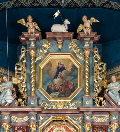 Zdjęcie nr 36: Kamienny ołtarz w jawiszowickim kościele uzyskał kształt prostopadłościanu. Otacza go drewniana obudowa podtrzymująca drewnianą mensę z portatylem. Jego przód zdobi drewniane antepedium ujęte profilowaną ramą z centralnym medalionem z monogramem Marii, otoczonym przez ornament roślinny. Ponad ołtarzem rozpościera się dwukondygnacyjna, architektoniczna nastawa ołtarzowa, flankowana przez dwie bramki. Struktura ołtarza dekorowana jest ciemnozieloną marmoryzacją. Pierwsza kondygnacja retabulum uzyskała trójosiowe założenie wsparte na dwustrefowym cokole, podzielonym płycinami z dekoracją akantową. Artykułują ją dwie pary kolumn o skręconych trzonach i kapitelach kompozytowych. Złocone w całości kolumny podtrzymują belkowanie o wysuniętym gzymsie, wyłamane na ich osi oraz przerwany trójkątny przyczółek. Pole środkowe nastawy wypełnia w całości nisza ujęta profilowaną, złoconą ramą w formie stojącego prostokąta zamkniętego trzema bokami z ośmioboku. W jej wnętrzu znajduje się obraz Matki Boskiej z Dzieciątkiem w typie Matki Boskiej Śnieżnej, zdobiony drewnianą złoconą i srebrzoną sukienką wotywną oraz koronami, a także dwie zasuwy z przedstawieniem św. Marcina, biskupa oraz bł. Salomei. Niszę środkową flankują znajdujące się pomiędzy kolumnami wąskie płyciny zwieńczone konchami. Na ich tle ustawiono figury św. Piotra i św. Pawła. Ponad nimi widoczne są na belkowaniu płaskorzeźbione i złocone girlandy kwiatowe oraz rozety. Na przerwanym przyczółku umieszczono dwie figury siedzących aniołów. Na mensie ołtarza centralnie ustawiono prostopadłościenne tabernakulum w drewnianej obudowie ujęte dwiema kolumienkami kompozytowymi o skręconych trzonach podtrzymujących belkowanie, do którego przymocowano świeczniki na sakramentki. Umieszczony na jego szczycie prosty tron eucharystyczny bez zaplecka flankują dwie figury uskrzydlonych aniołków. Drugą, jednoosiową kondygnację nastawy ujmuje także para złoconych kolumn o skręconych trzonach i kapitelach kompozytowych, ustawionych na cokołach, dźwigających imposty. Pomiędzy kolumnami nad polem z obrazem Wniebowzięcia Matki Boskiej widoczny jest wysunięty fragment gzymsu. Obraz ujęty został złoconą i profilowaną ramą w formie kwadratu o ściętych narożach. Po bokach obrazu na płycinie rozmieszczono złocone dekoracje akantowe. W zwieńczeniu na belkowaniu usytuowano dwa putta flankujące rzeźbę apokaliptycznego baranka leżącego na księdze. Obie kondygnacje ujmują uszaki z akantu suchego. Po bokach nastawy usytuowano dwie bramki flankowane pilastrami. Ich zwężające się ku dołowi trzony podtrzymują nadwieszony łuk półkolisty. Całość zamyka gzyms z centralnie usytuowanym cokołem, na którym stoją figury św. Stanisława i św. Wojciecha. Po ich bokach figur przy ścianach ustawiono rzeźbione i złocone wazony z kwiatami. 